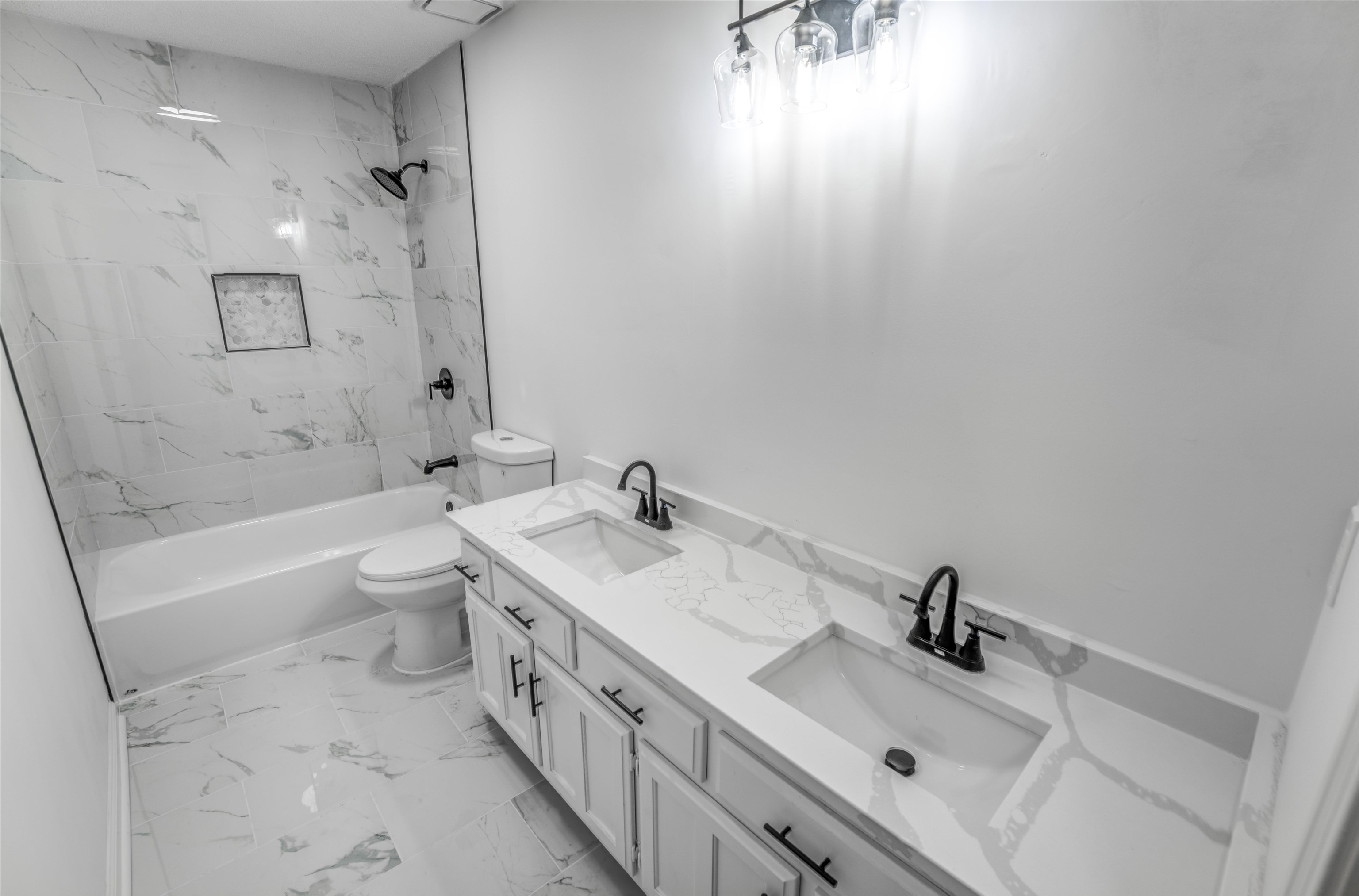 Full bathroom featuring toilet, tiled shower / bath, and vanity