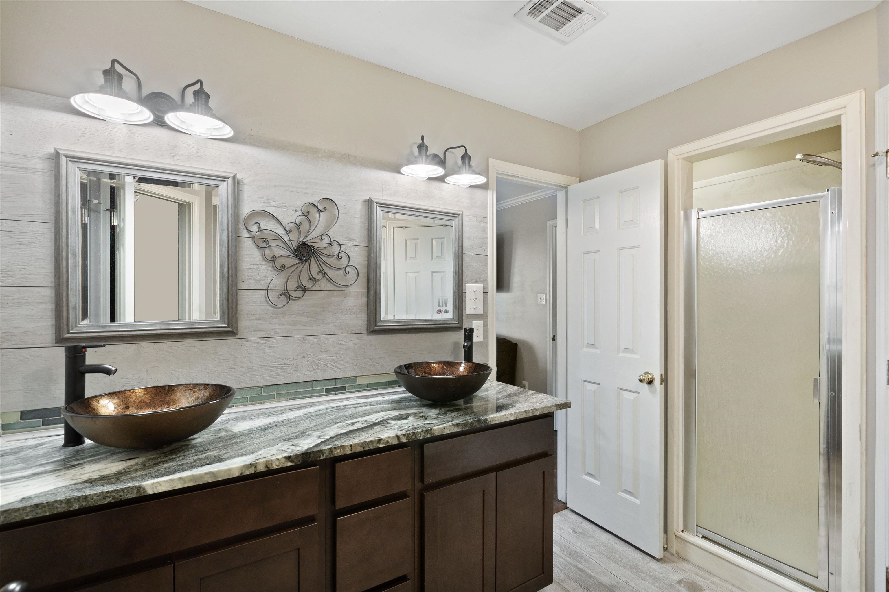 Bathroom with vanity, hardwood / wood-style flooring, and an enclosed shower