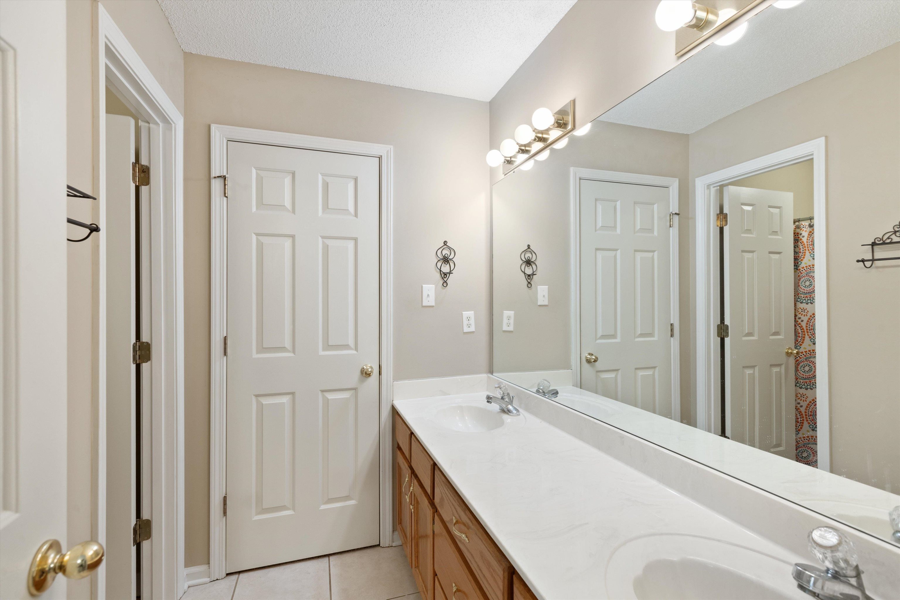 Bathroom with vanity, a textured ceiling, and tile patterned flooring