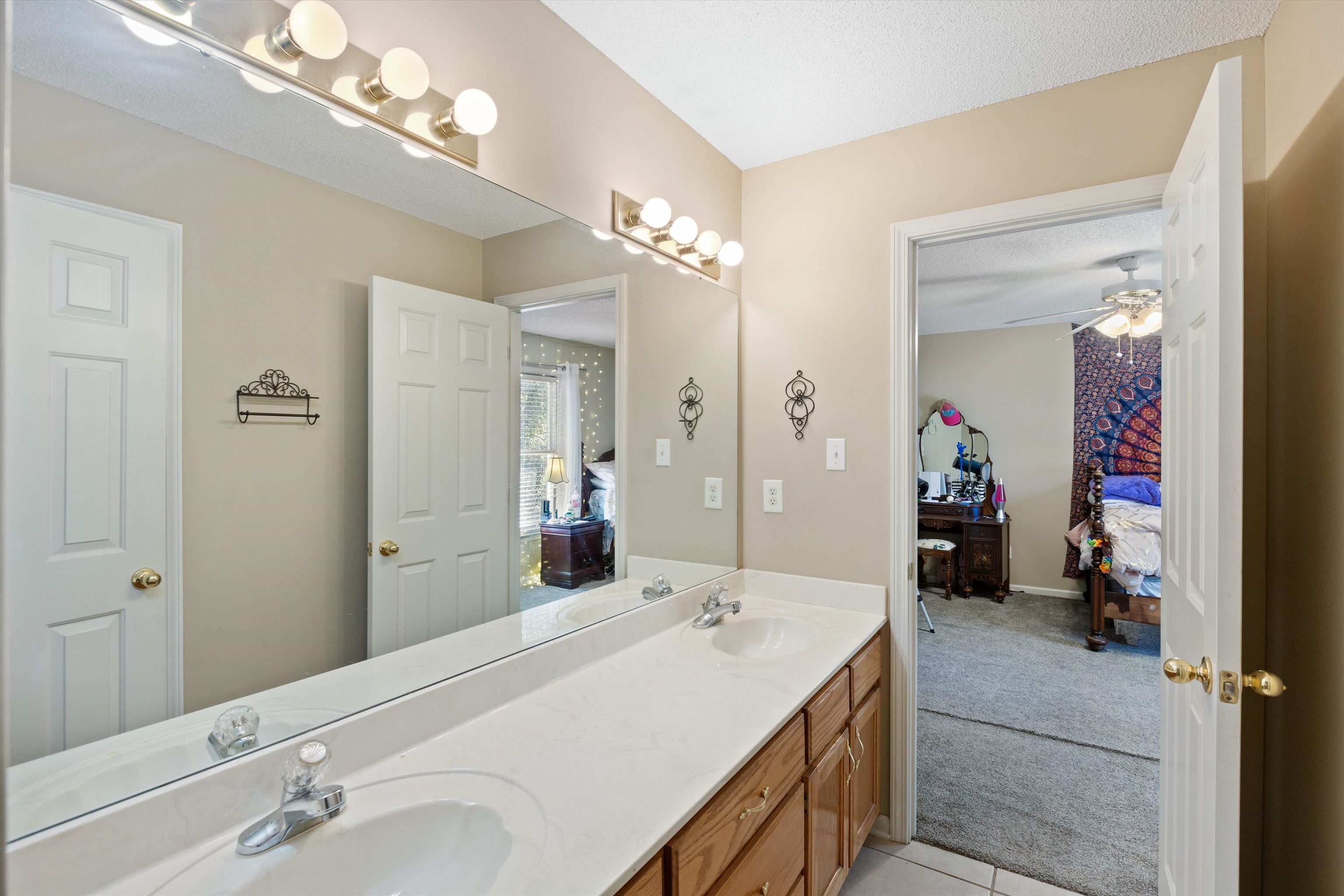 Bathroom featuring vanity, tile patterned flooring, a textured ceiling, and ceiling fan