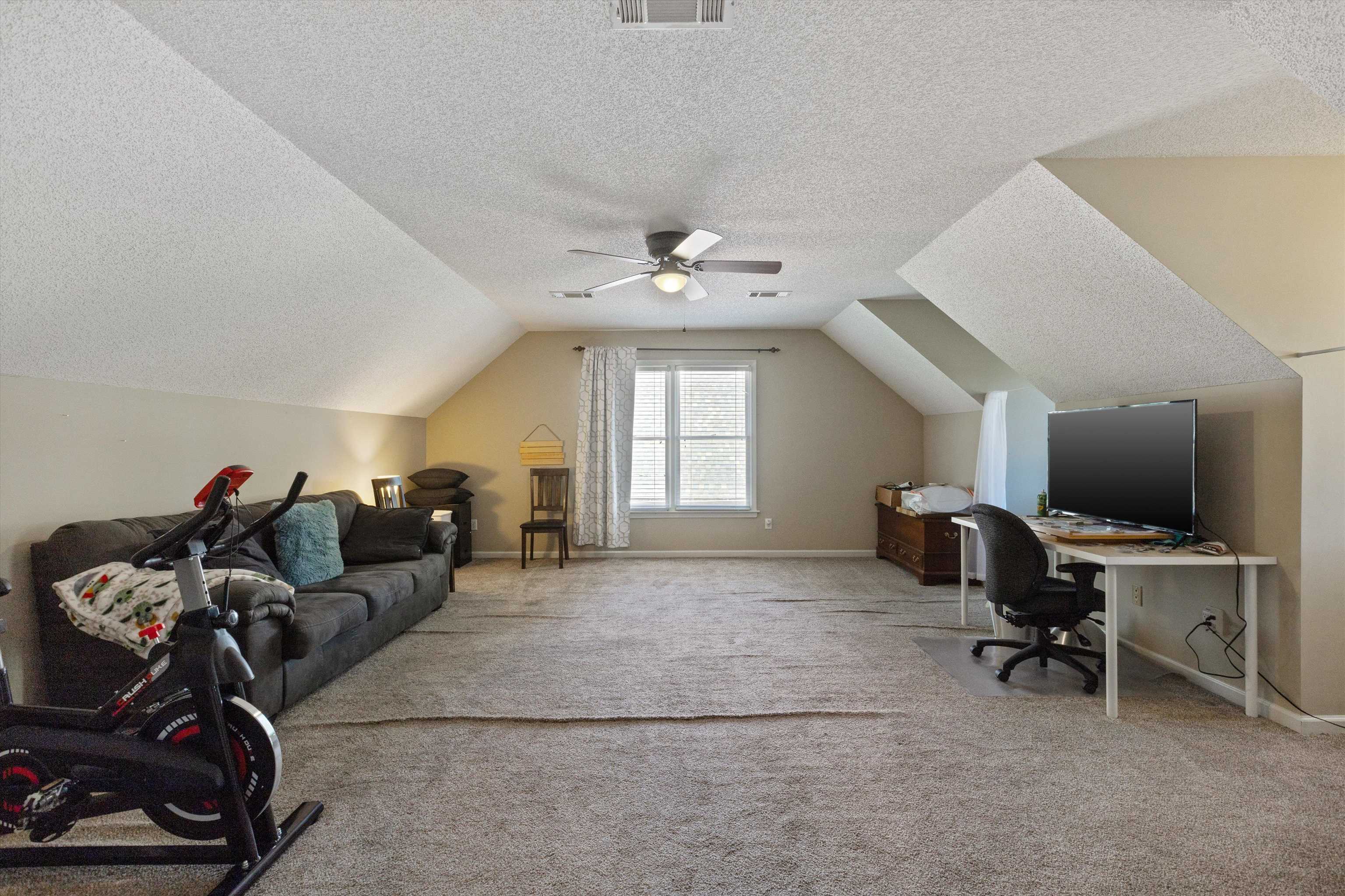 Office space featuring a textured ceiling, lofted ceiling, and carpet floors