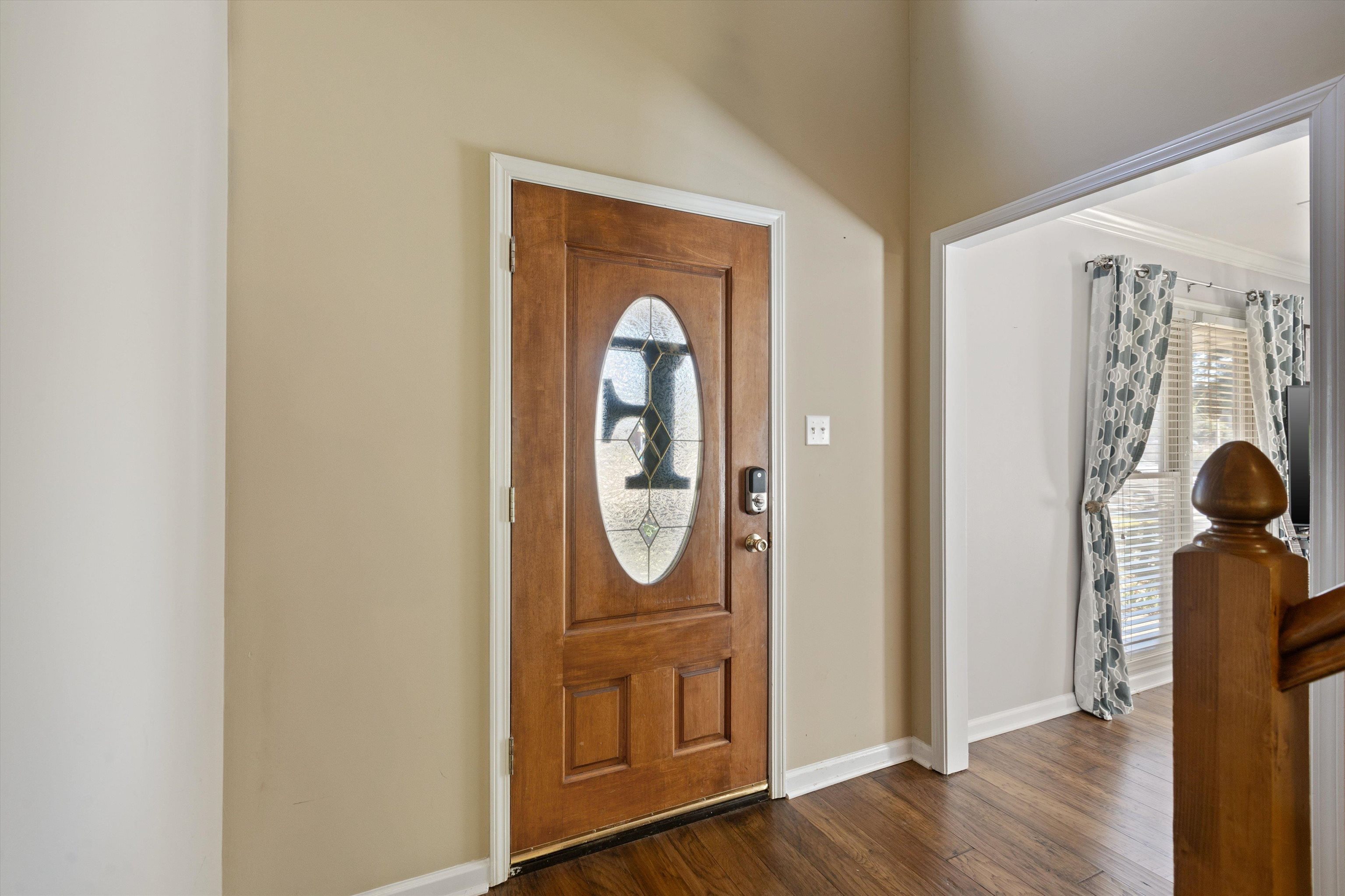 Entrance foyer featuring dark wood-type flooring, crown molding, and a wealth of natural light