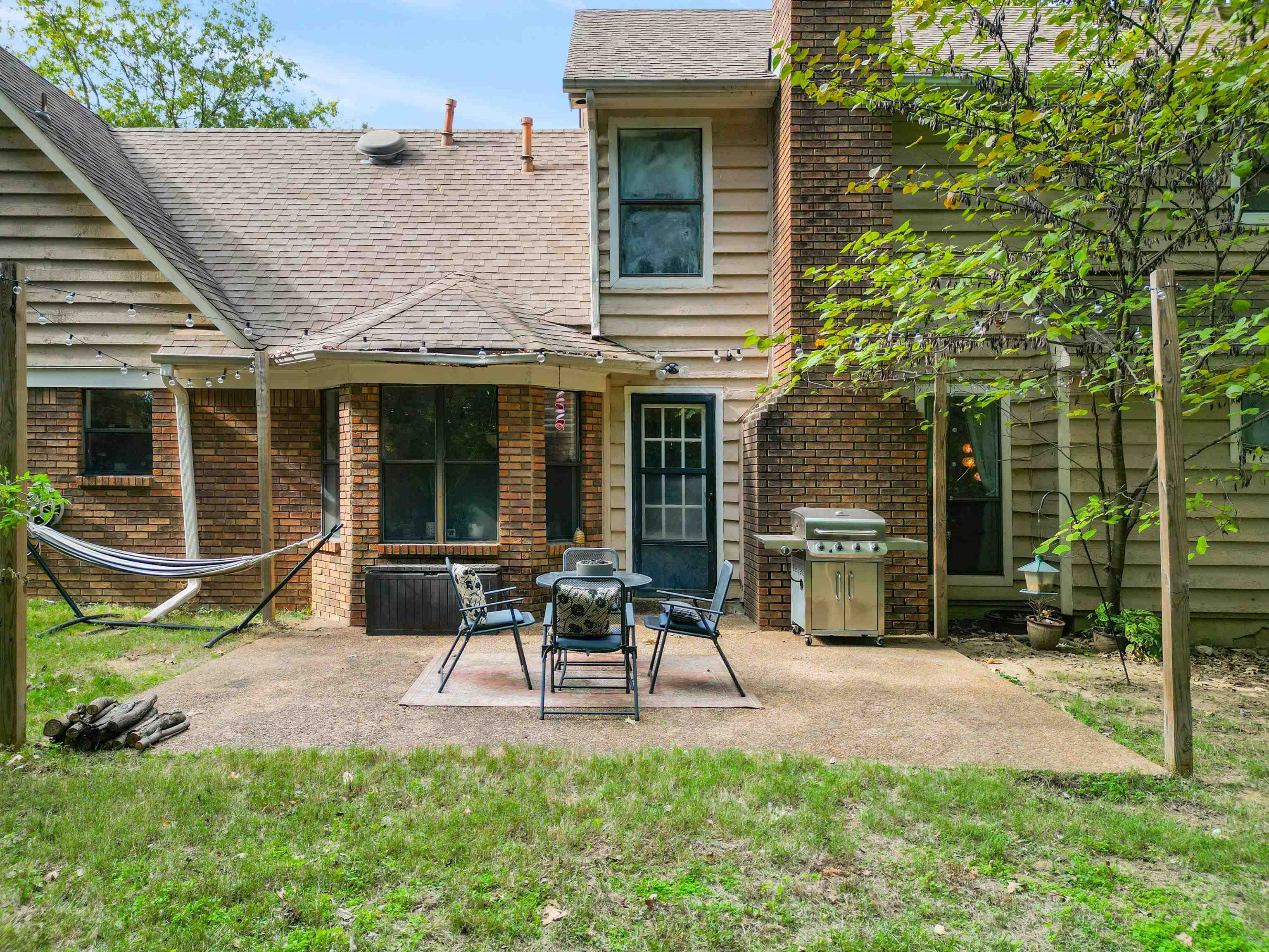 Rear view of house featuring a patio and a lawn