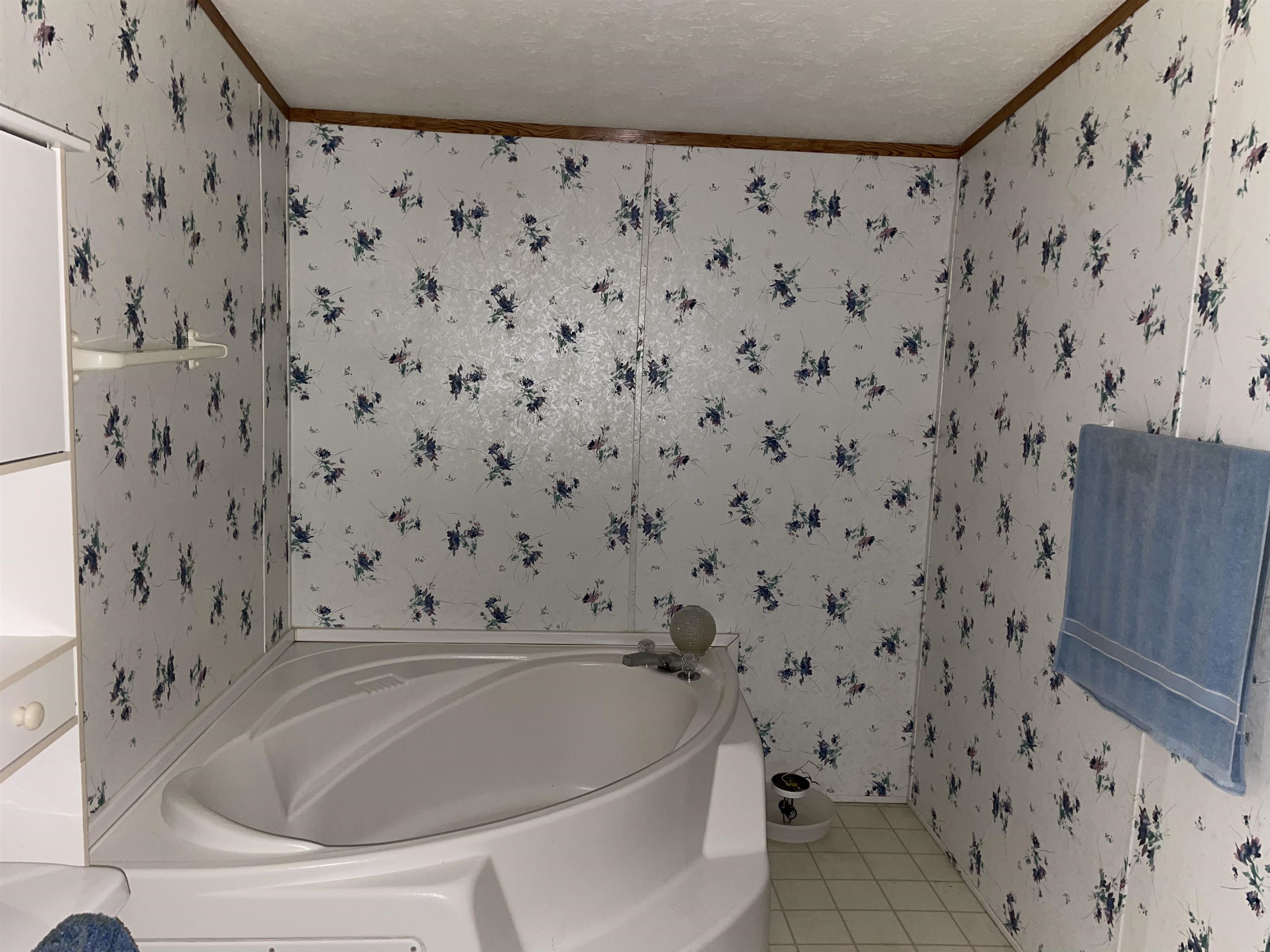 Bathroom featuring crown molding, a textured ceiling, a bath, and tile patterned flooring