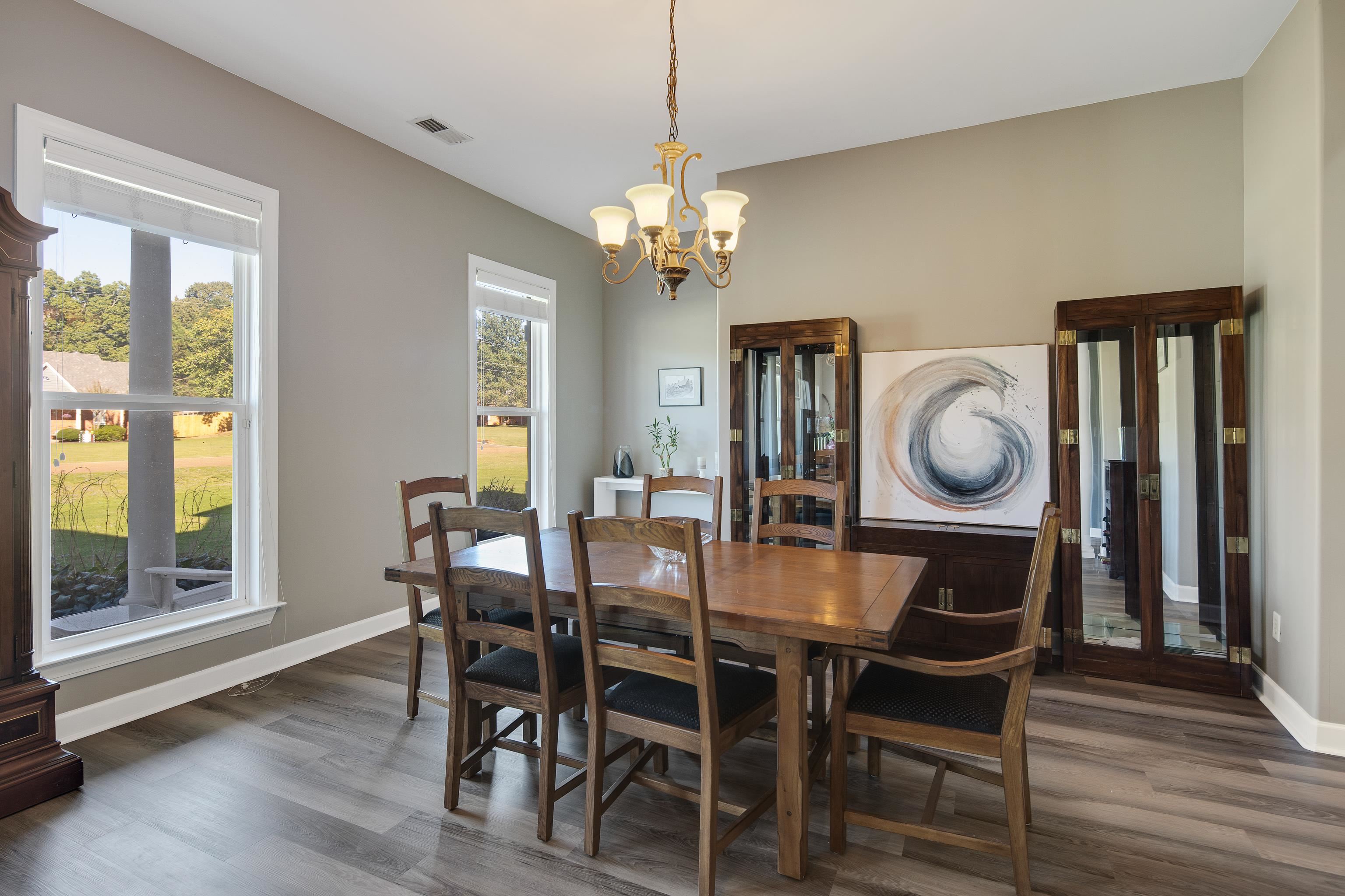 Dining room with an inviting chandelier and dark hardwood / wood-style flooring