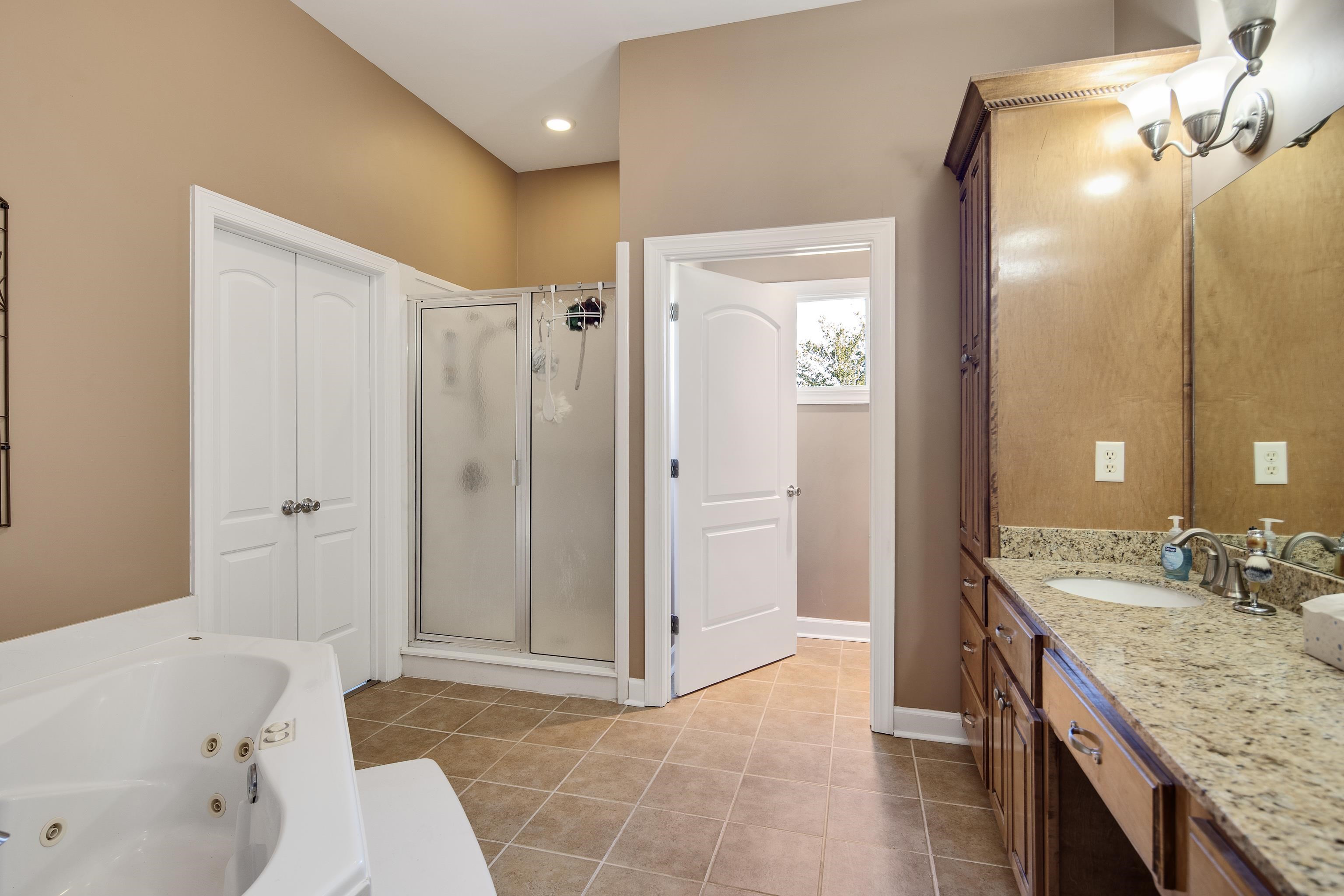 Bathroom with vanity, tile patterned floors, and shower with separate bathtub