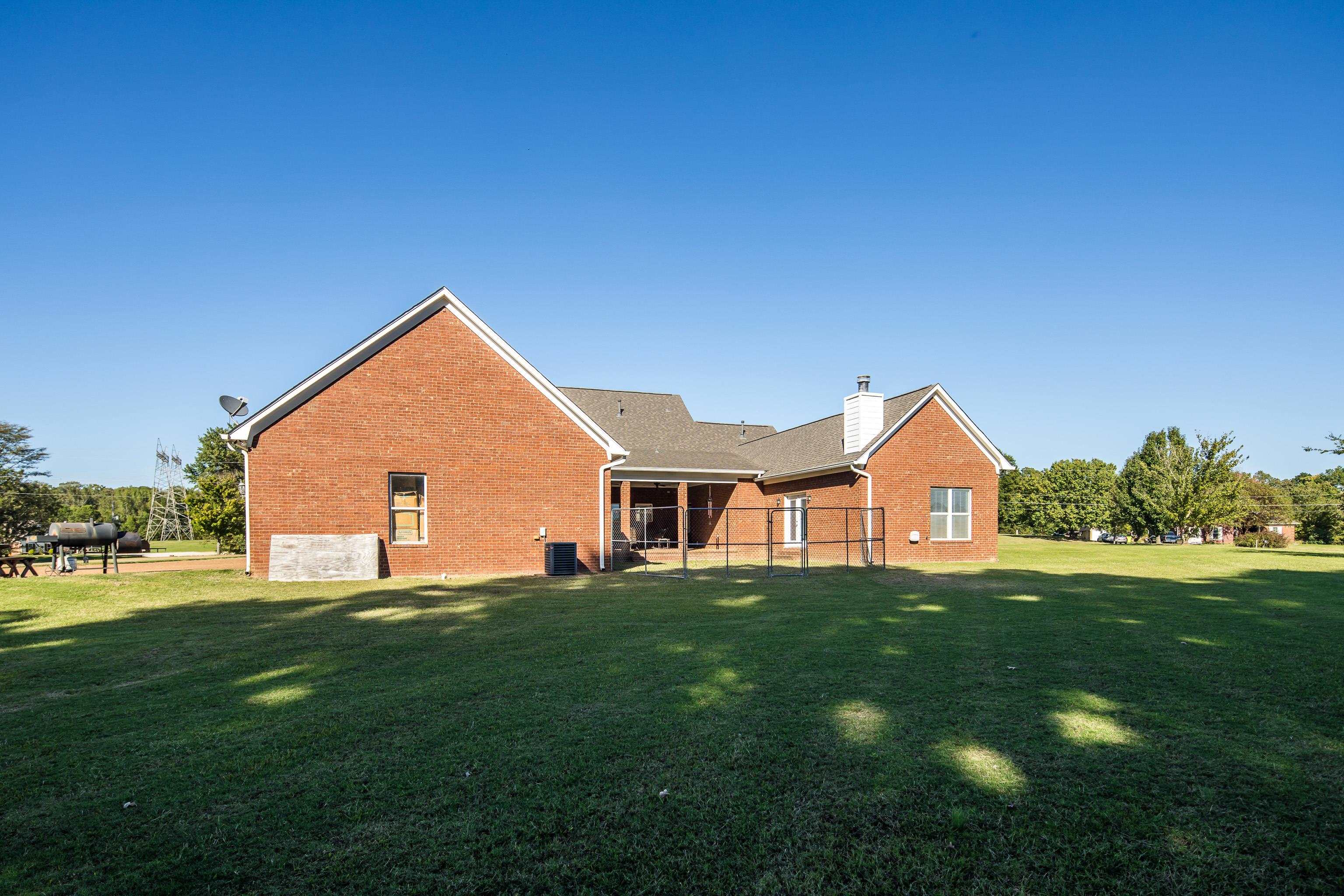 Back of house featuring central AC and a yard