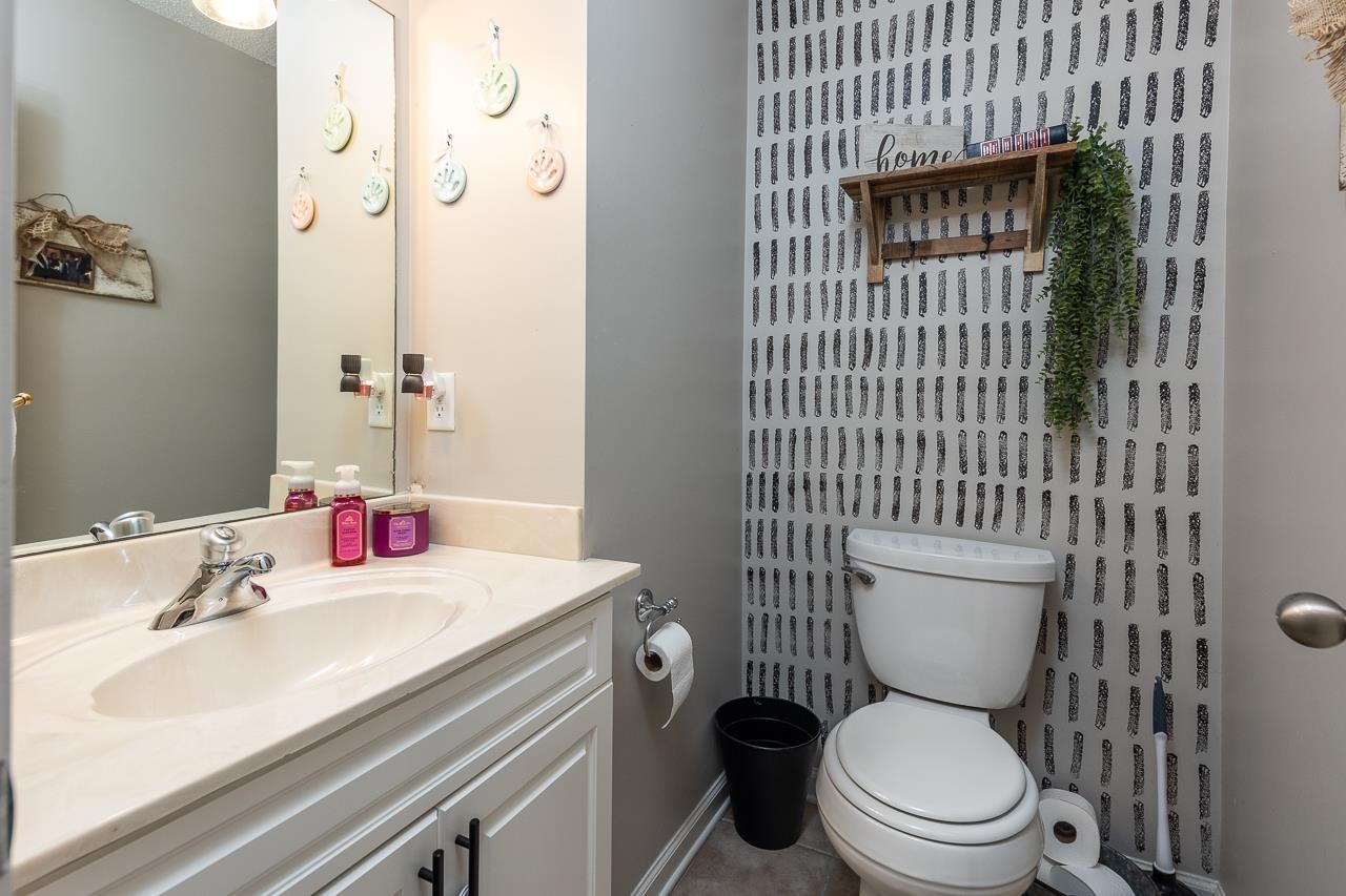 Bathroom with toilet, vanity, and tile patterned flooring