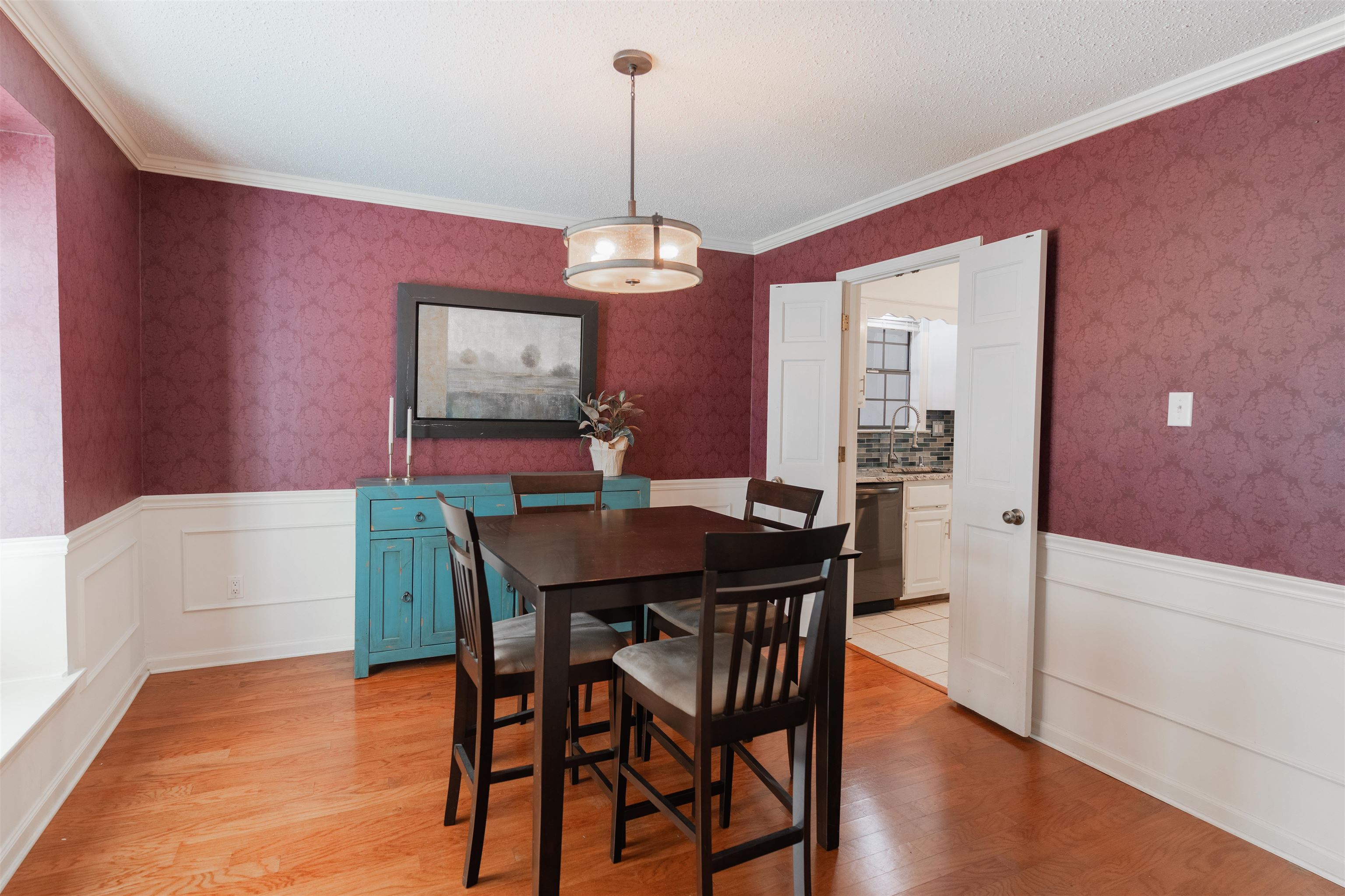 Dining area featuring ornamental molding, sink, and light hardwood / wood-style flooring