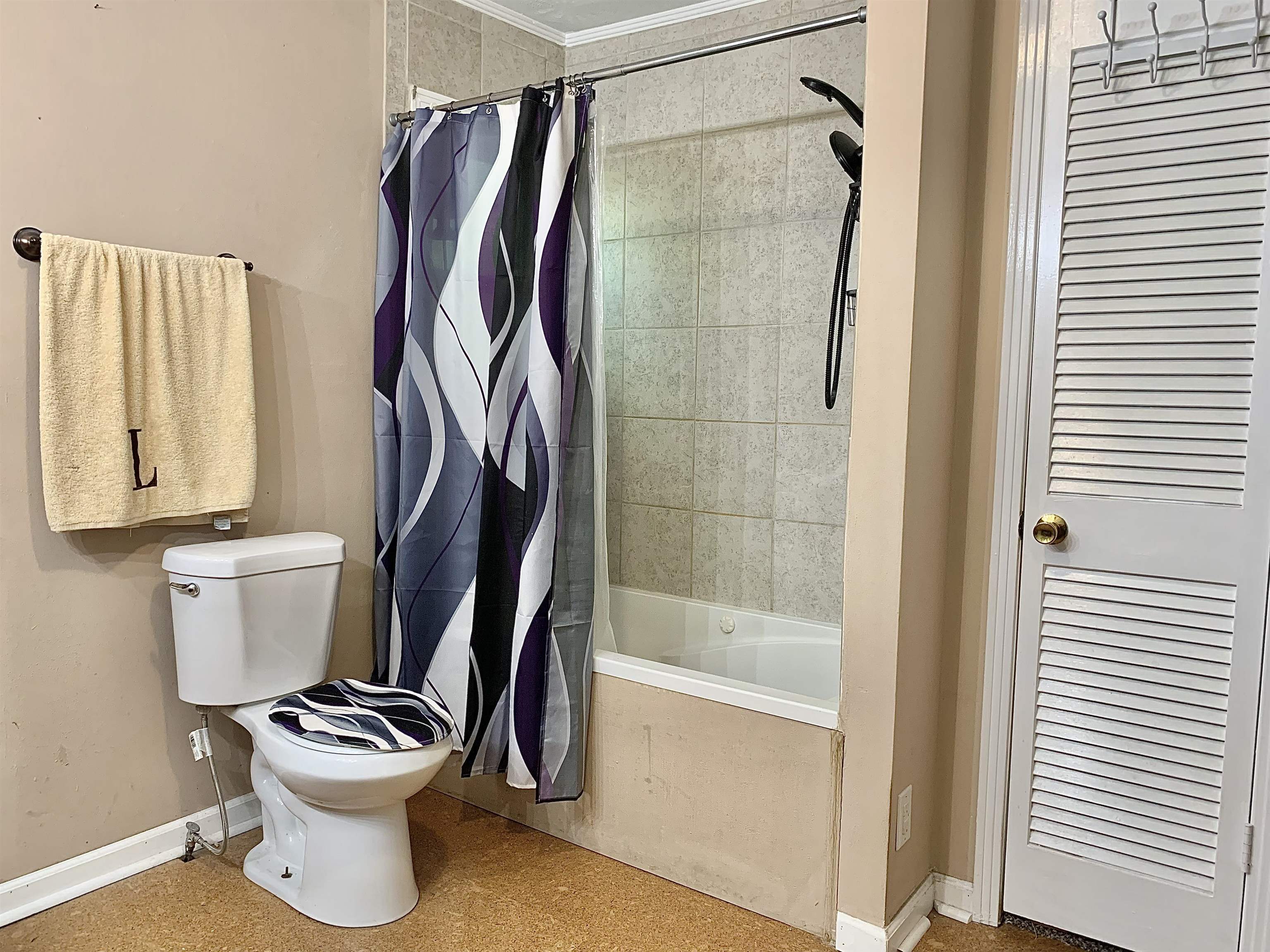 Bathroom featuring toilet, crown molding, and shower / bath combination with curtain