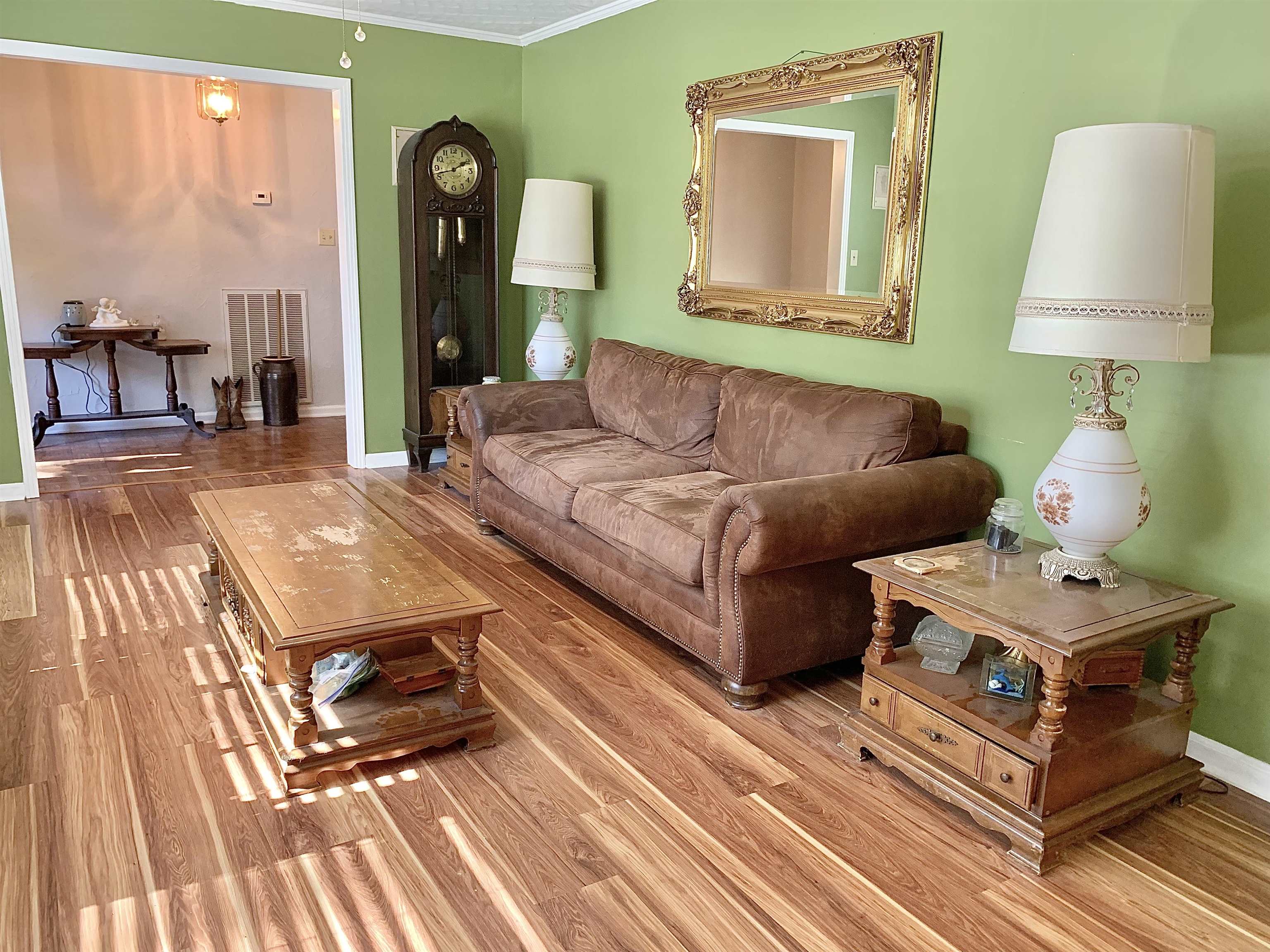 Living room with ornamental molding and light hardwood / wood-style flooring