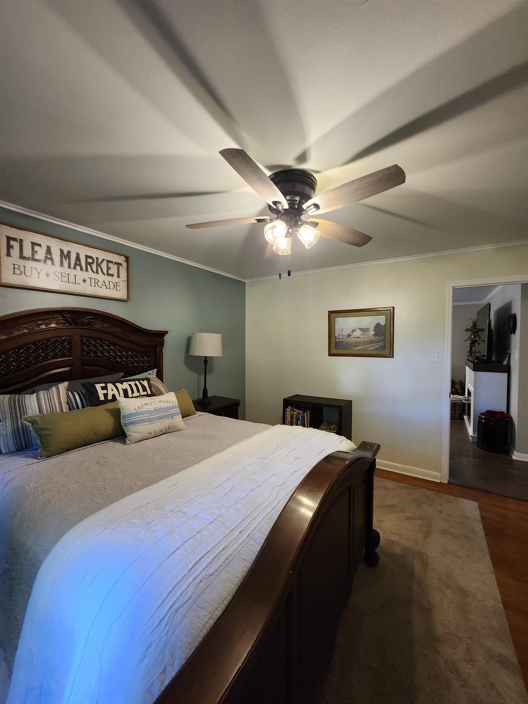 Bedroom with dark hardwood / wood-style flooring, ornamental molding, and ceiling fan