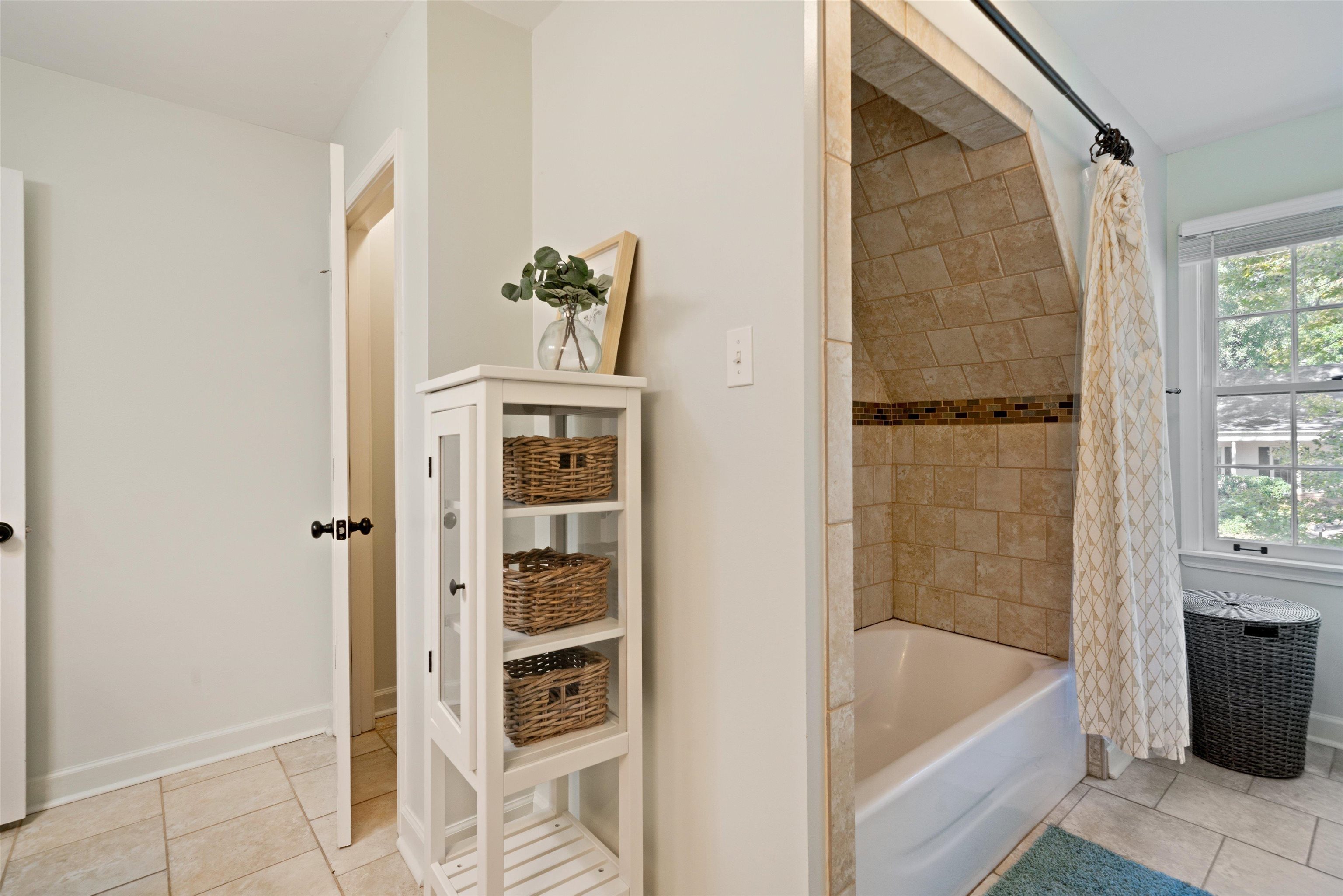 Bathroom featuring tile patterned flooring and shower / bathtub combination with curtain