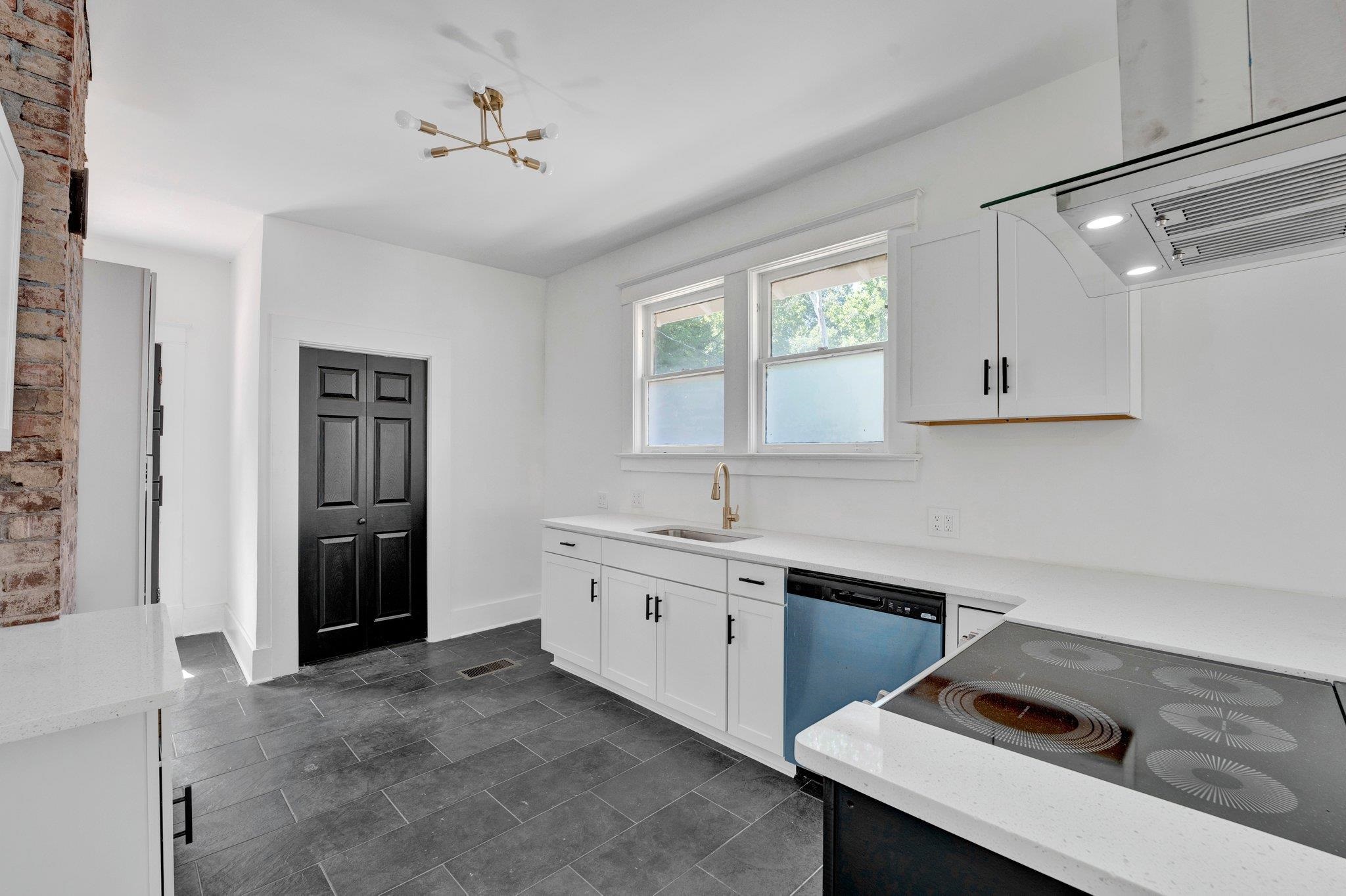 Kitchen with sink, range, white cabinetry, stainless steel dishwasher, and exhaust hood
