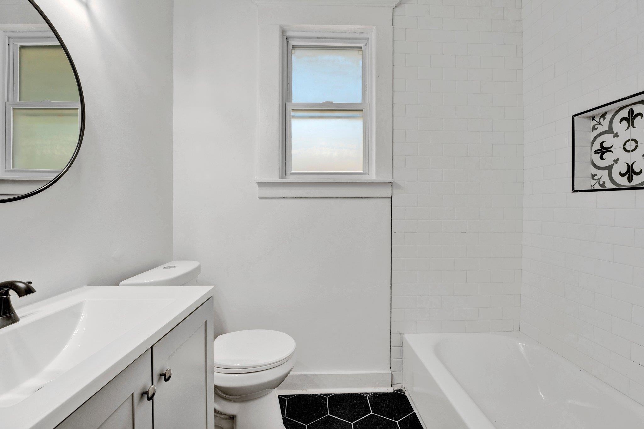 Full bathroom featuring toilet, tiled shower / bath, vanity, and tile patterned floors