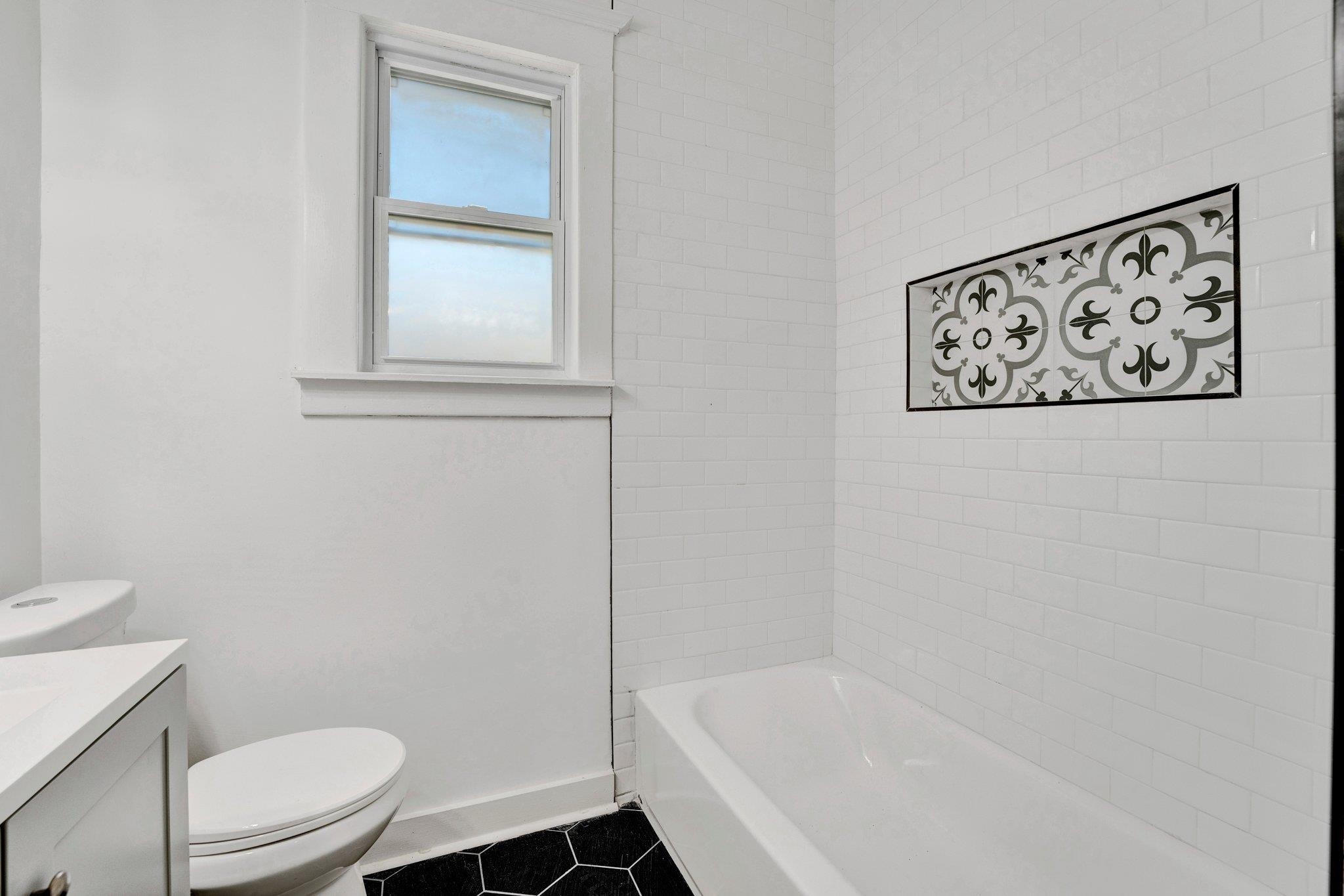 Full bathroom with vanity, toilet, tile patterned flooring, and tiled shower / bath
