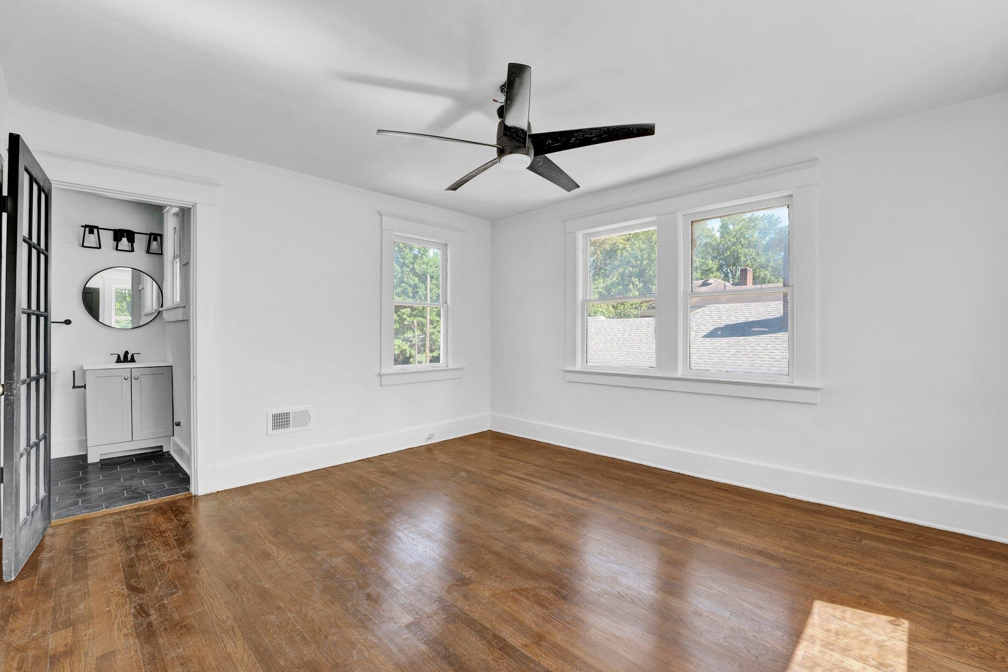 Interior space with ceiling fan and dark hardwood / wood-style flooring