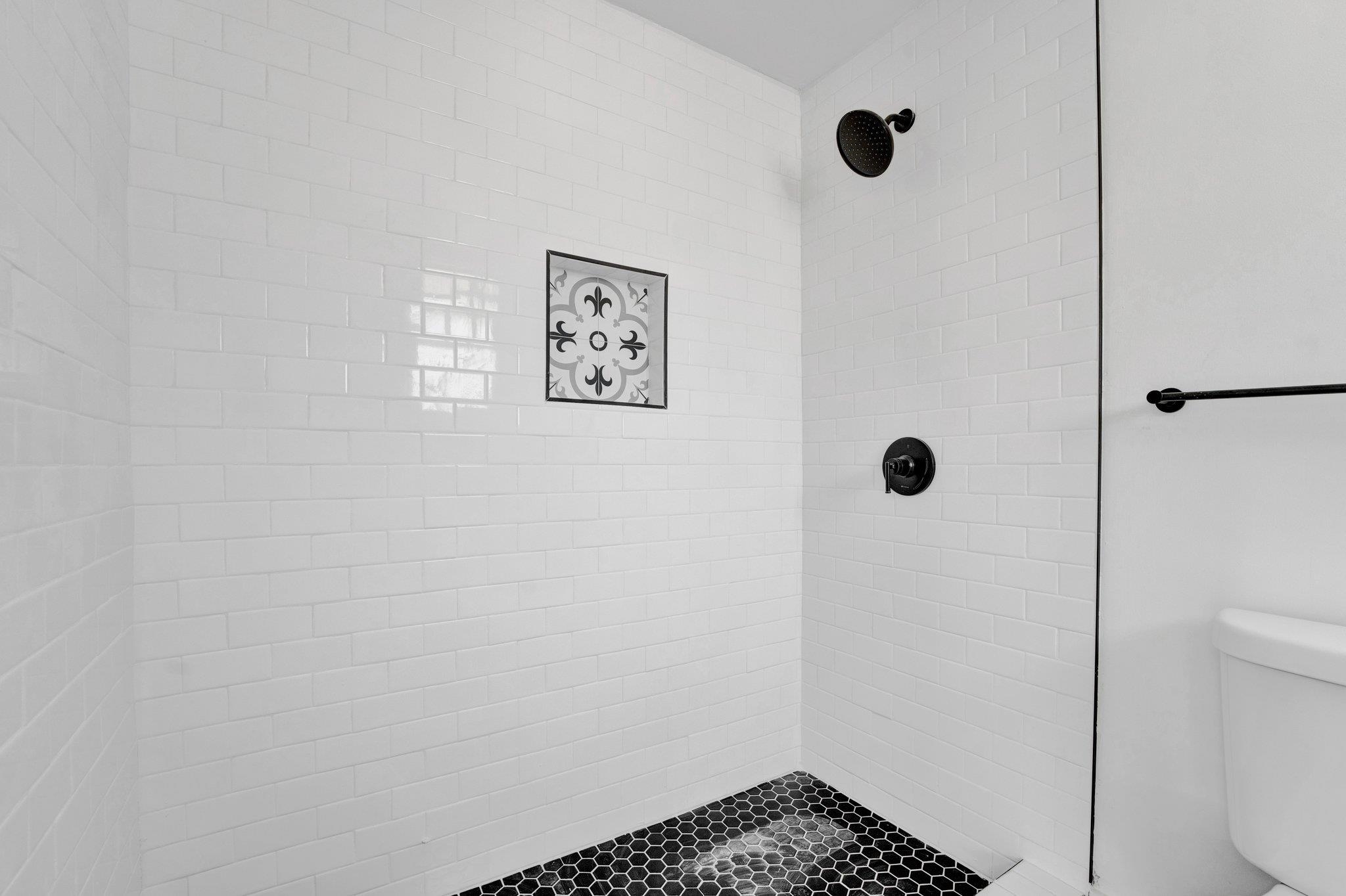 Bathroom featuring a tile shower and toilet