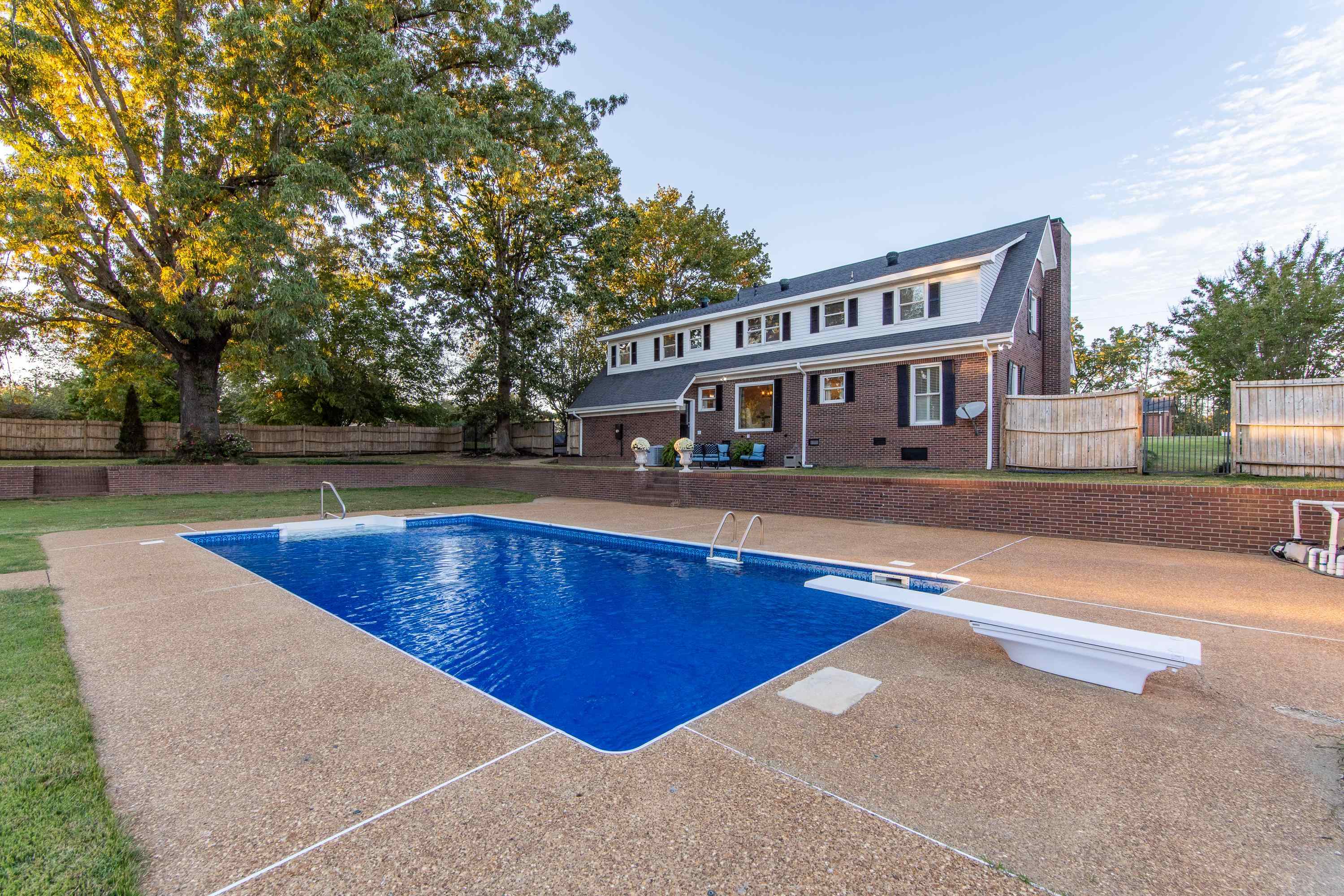 View of swimming pool with a patio and a diving board