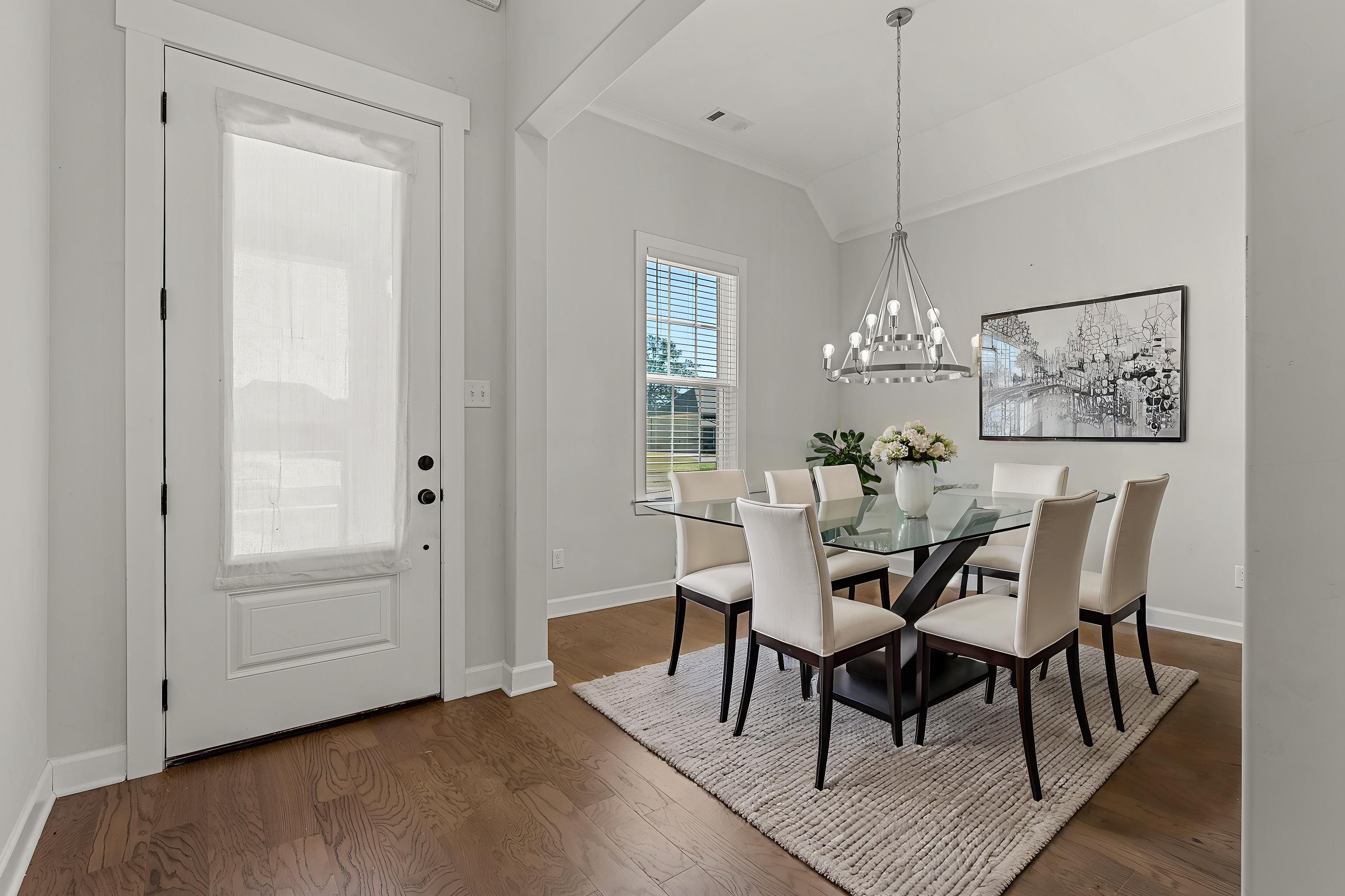 Dining room featuring dark wood-type flooring, a notable chandelier, and lofted ceiling