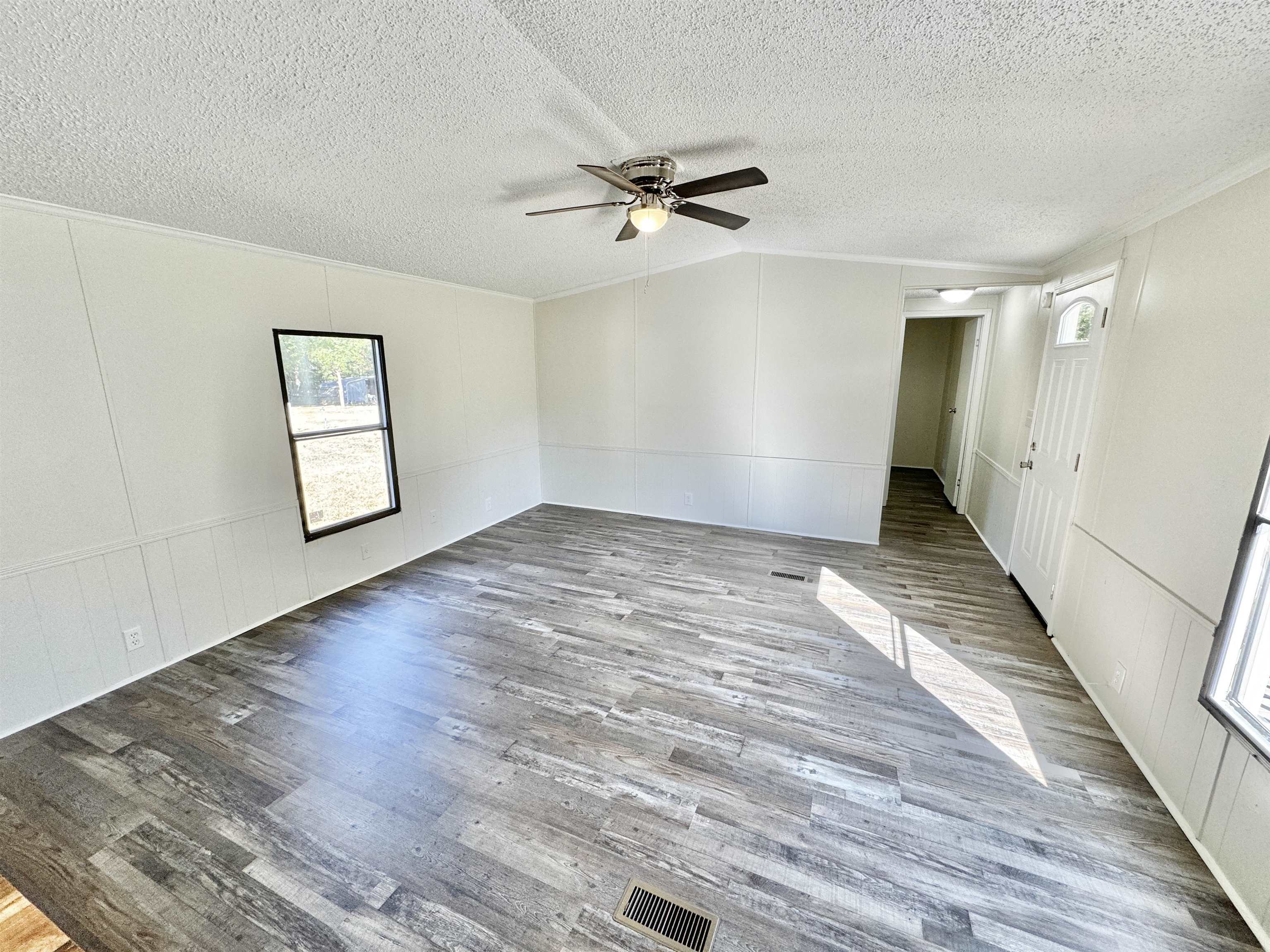 Empty room featuring ceiling fan, a textured ceiling, and hardwood / wood-style floors