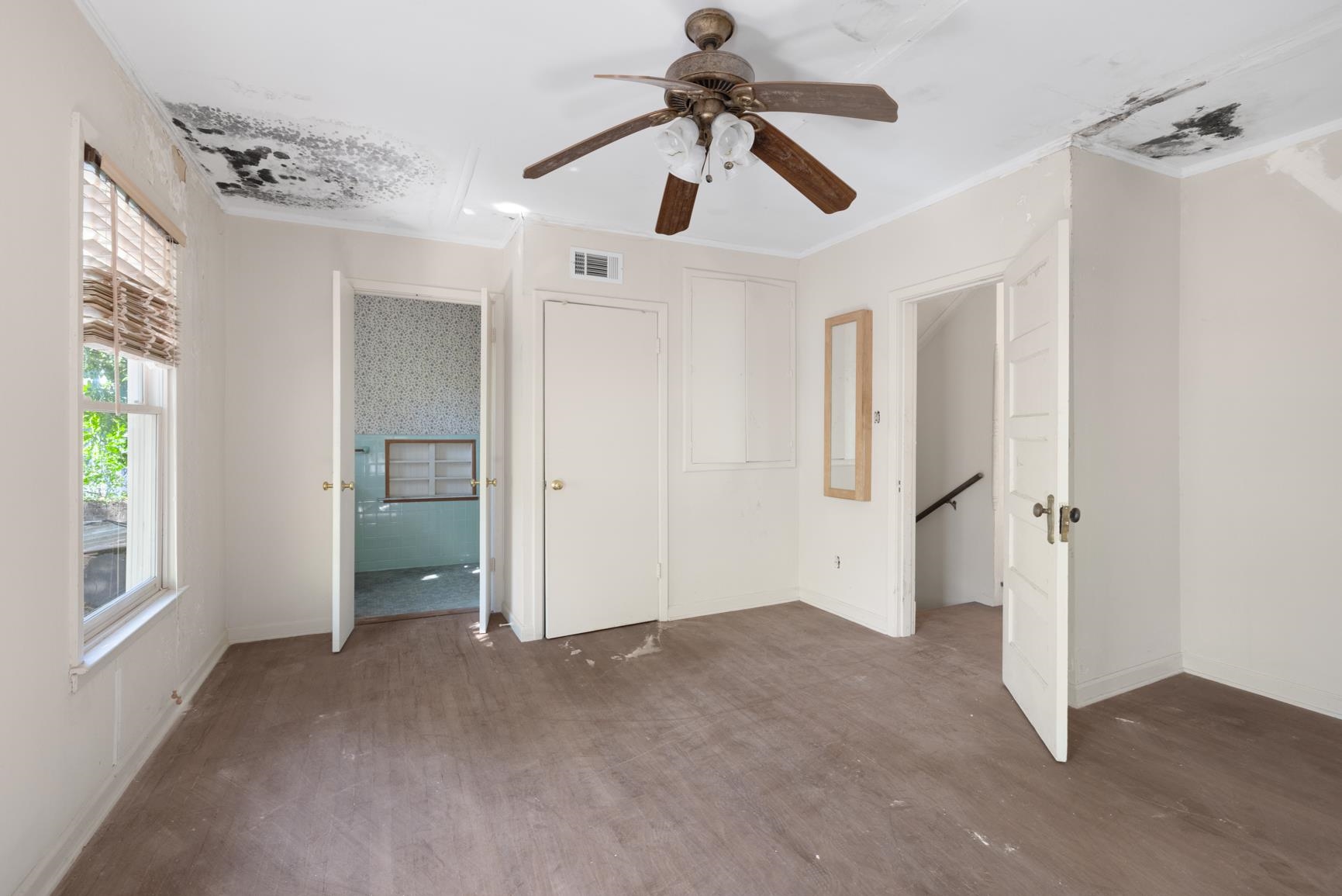 Unfurnished bedroom with crown molding, dark hardwood / wood-style floors, and ceiling fan