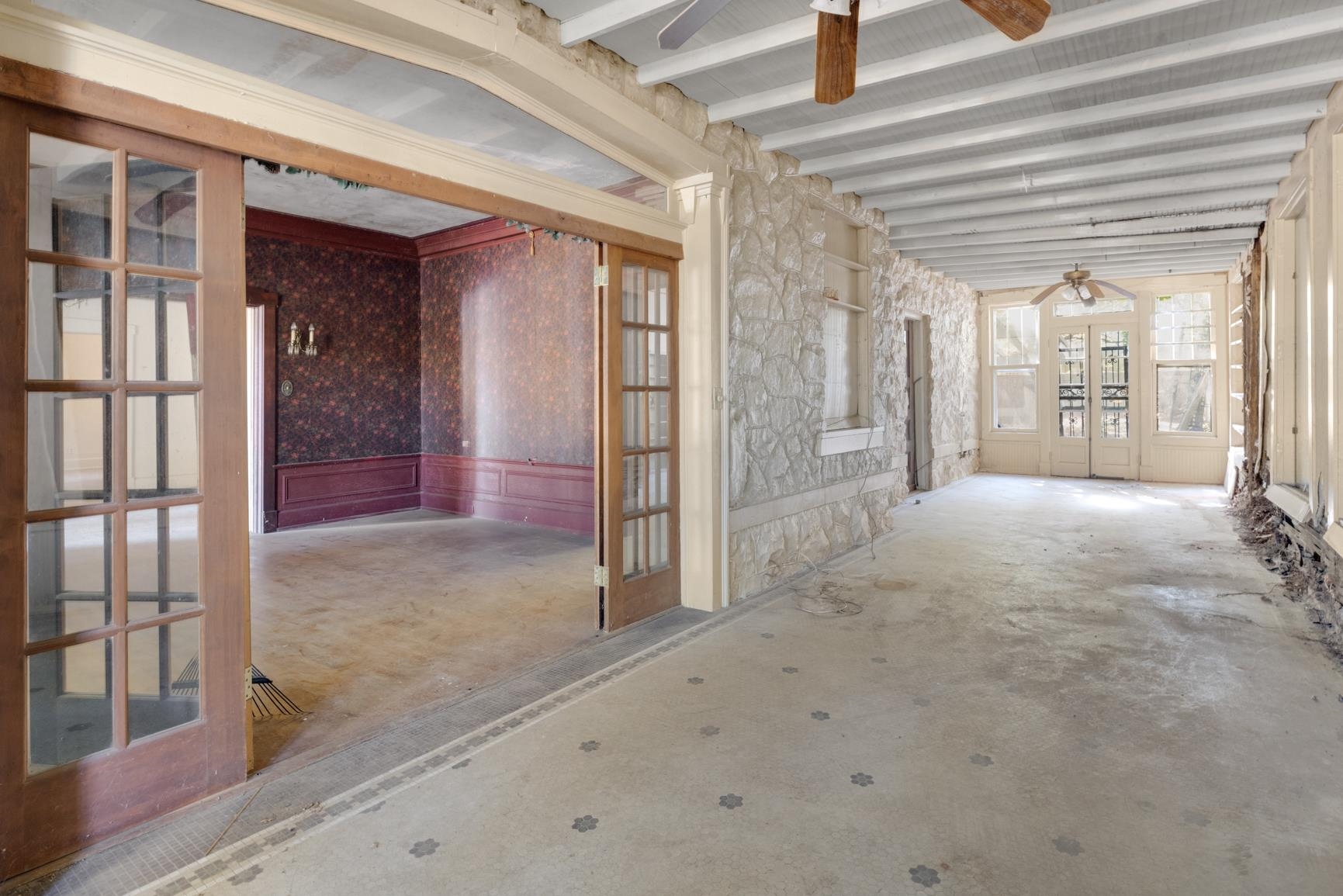 Misc room with ceiling fan, beam ceiling, and concrete flooring