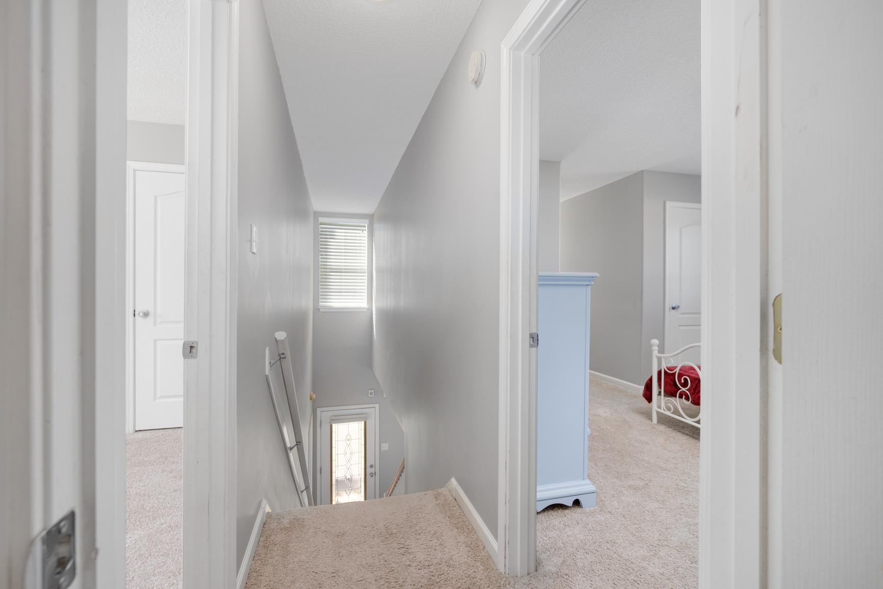 Corridor featuring light colored carpet