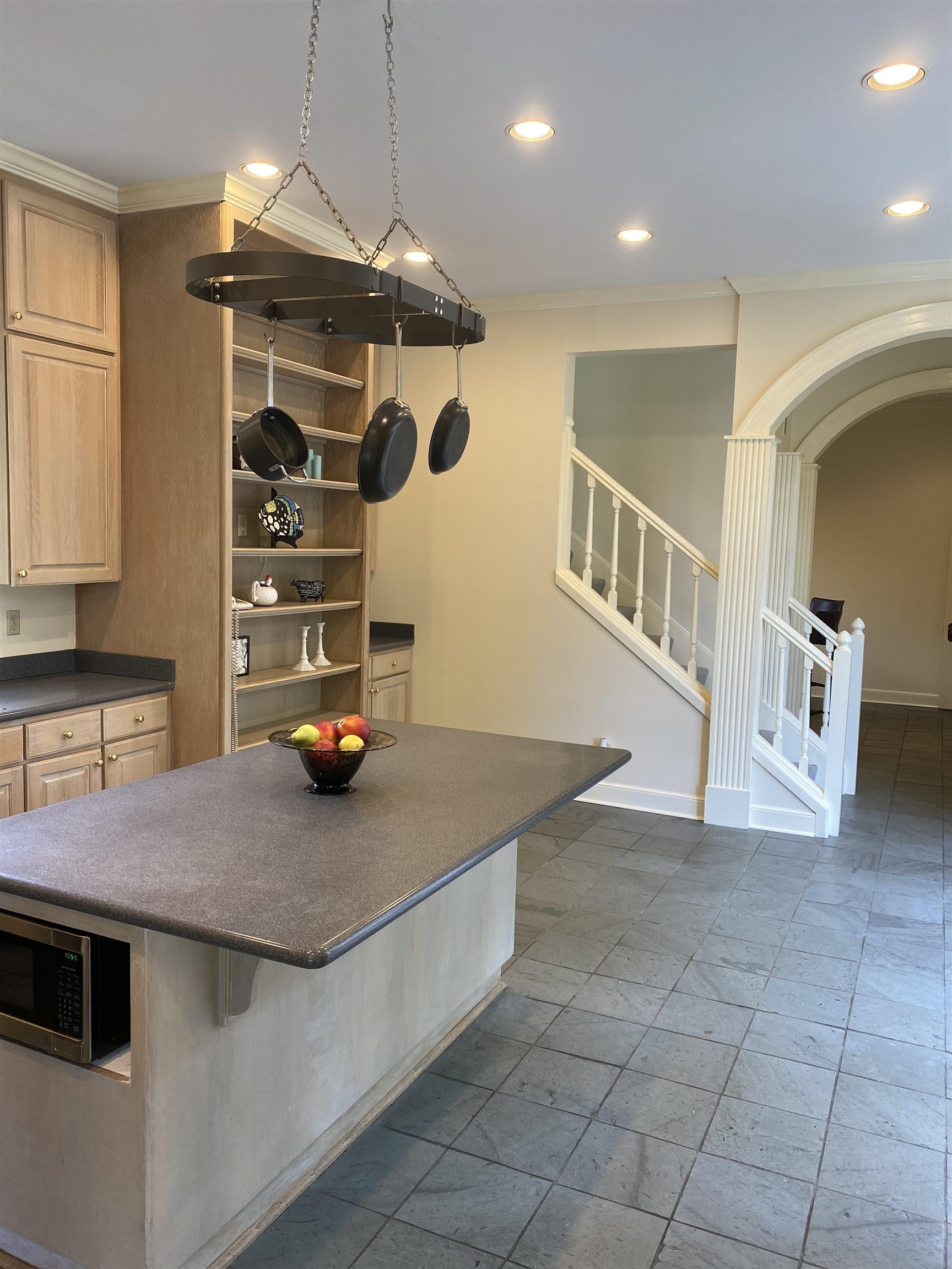 Kitchen featuring ornamental molding, dark tile patterned floors, a breakfast bar area, and light brown cabinets