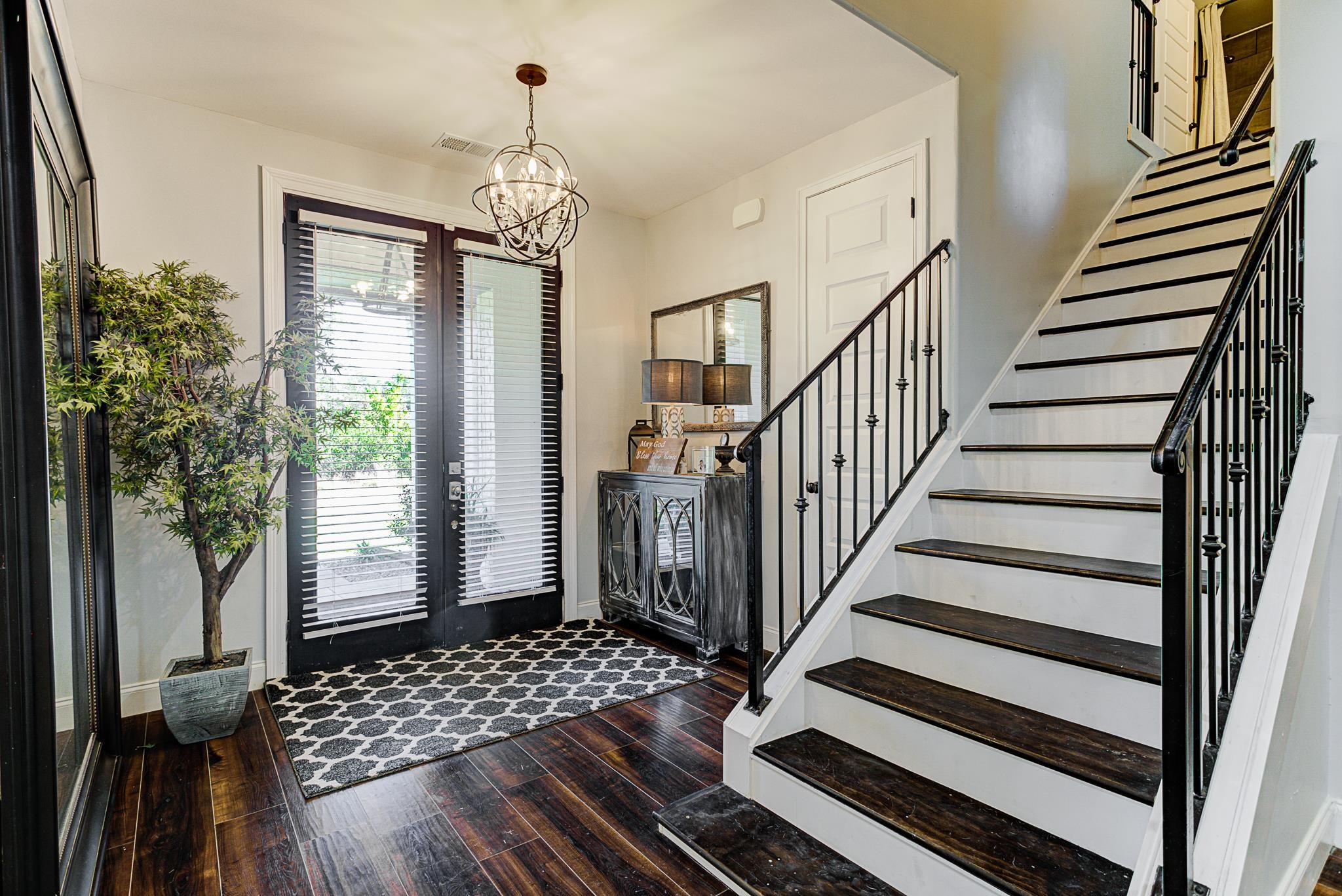 Entrance foyer featuring dark wood-type flooring, an inviting chandelier, and french doors