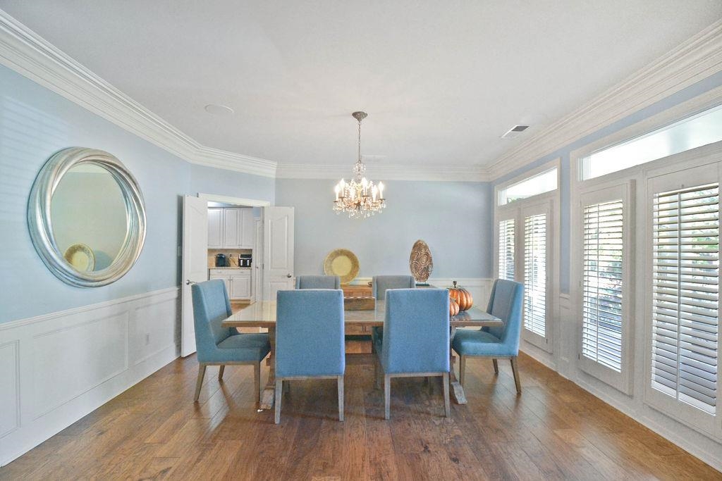 Dining area featuring ornamental molding, a notable chandelier, and dark hardwood / wood-style floors