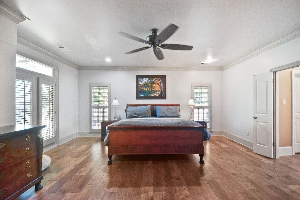 Bedroom featuring crown molding, hardwood / wood-style floors, a textured ceiling, and ceiling fan