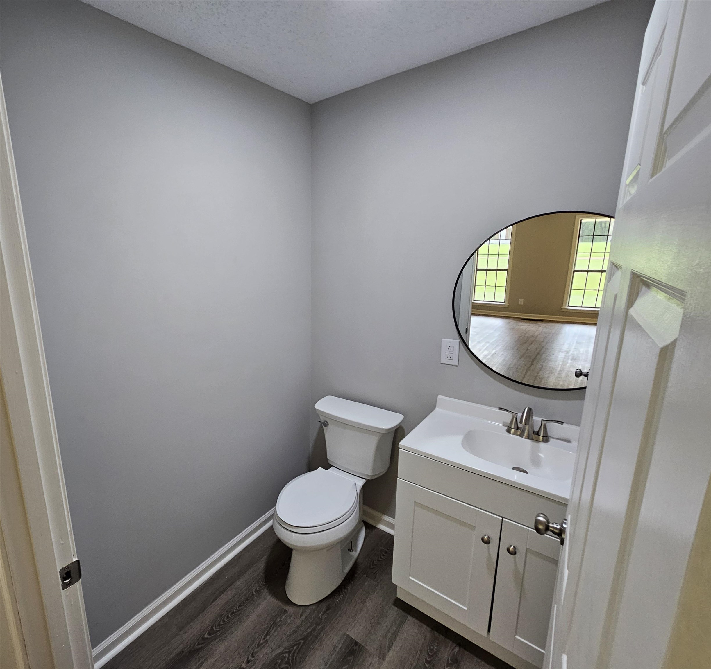 Bathroom featuring vanity, a textured ceiling, hardwood / wood-style flooring, and toilet