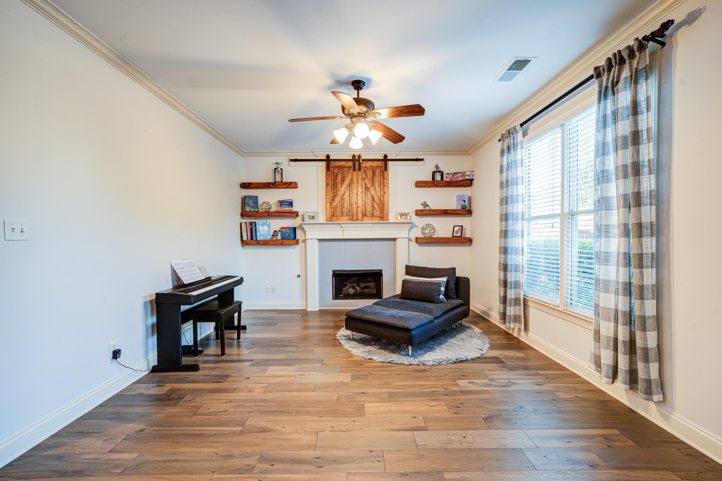 Living area featuring hardwood / wood-style flooring, a healthy amount of sunlight, and ornamental molding