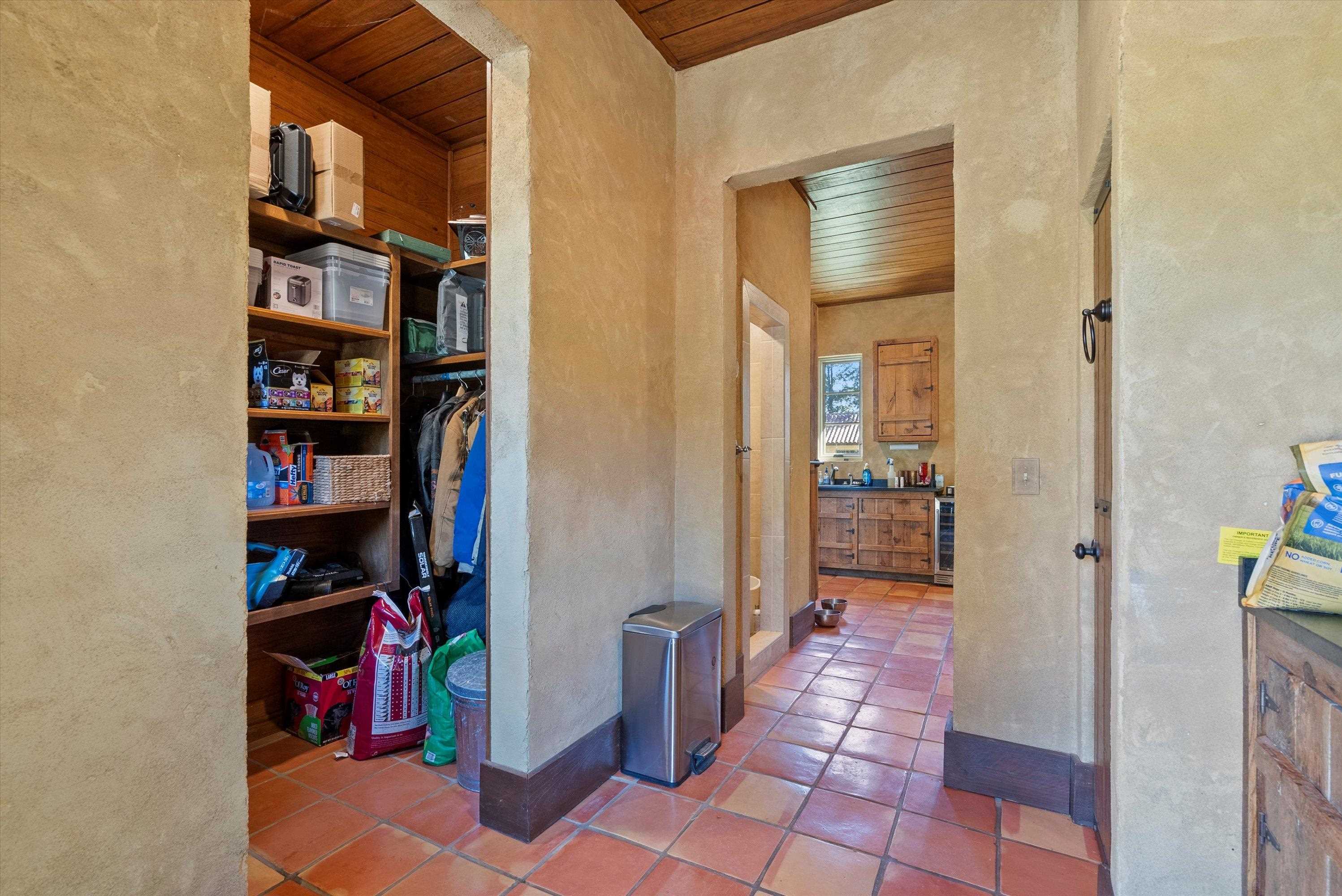 Hallway with beverage cooler, wooden ceiling, and tile patterned floors