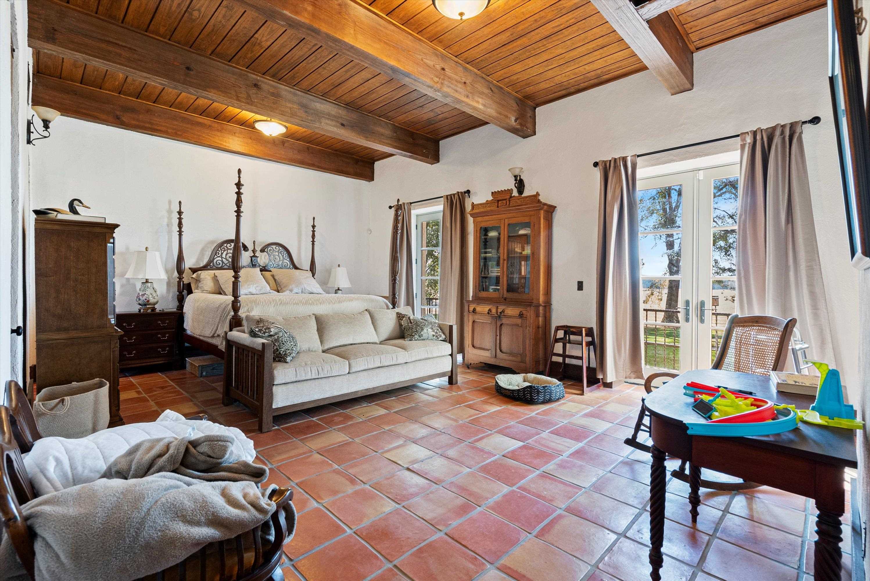 Tiled bedroom featuring wood ceiling, french doors, and beam ceiling