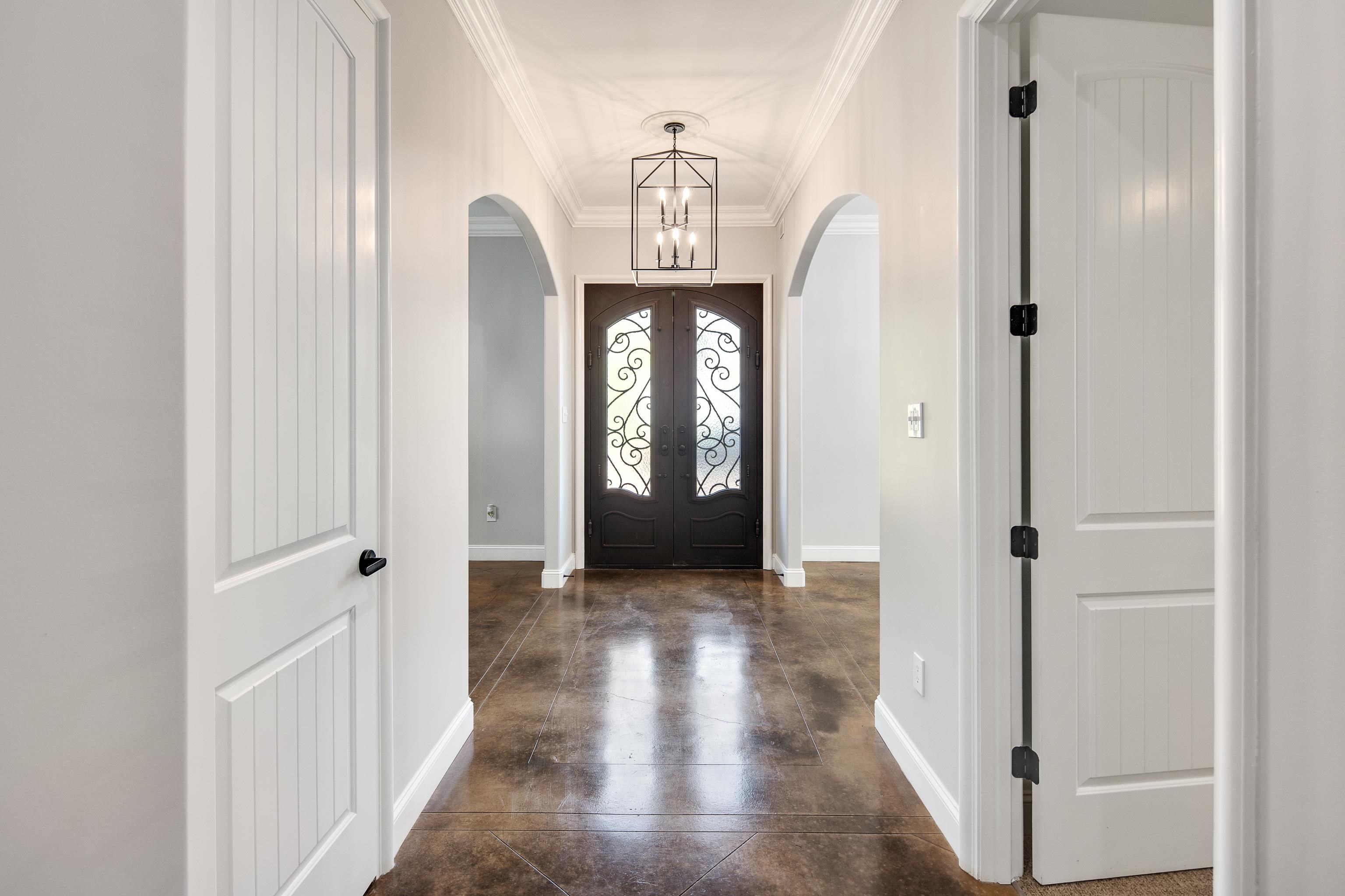 Entrance foyer with ornamental molding and a chandelier