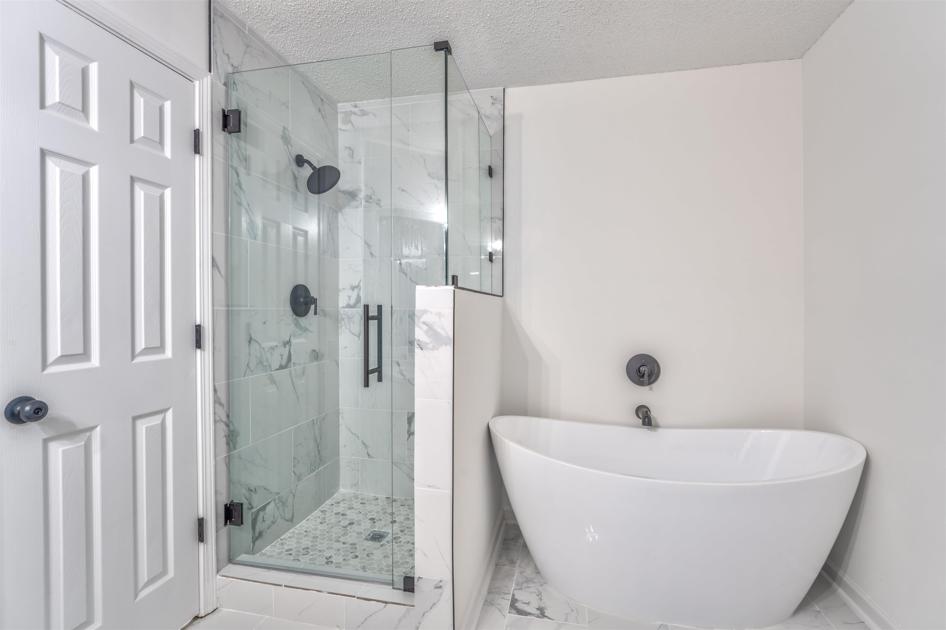 Bathroom featuring shower with separate bathtub and a textured ceiling