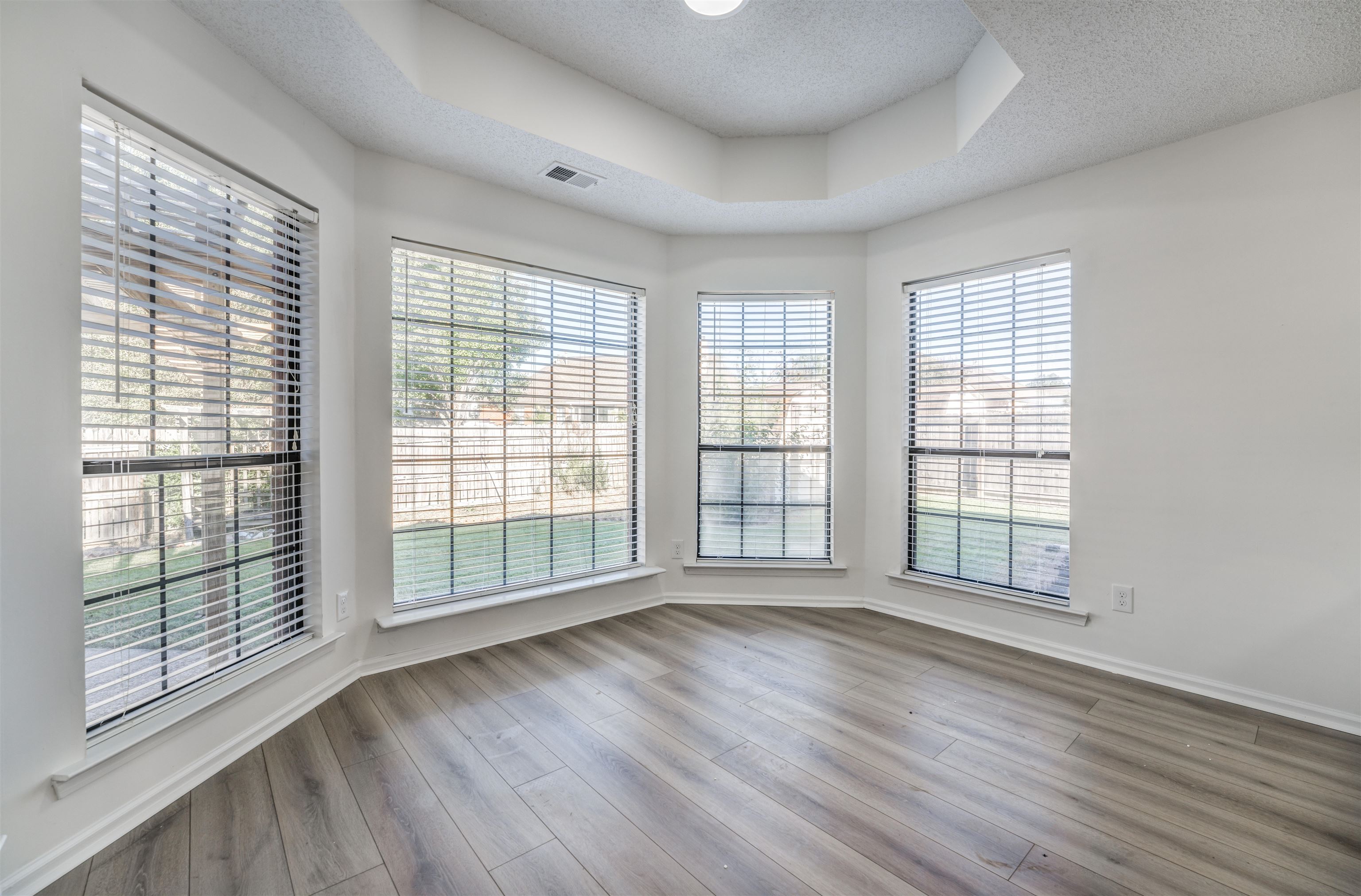 Spare room with hardwood / wood-style flooring, a textured ceiling, and plenty of natural light