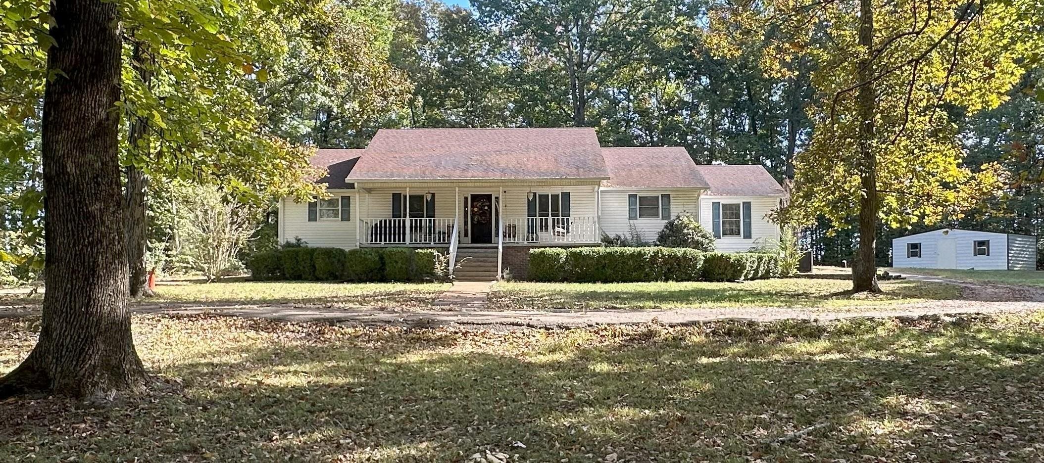 View of front of home with covered porch and a front lawn
