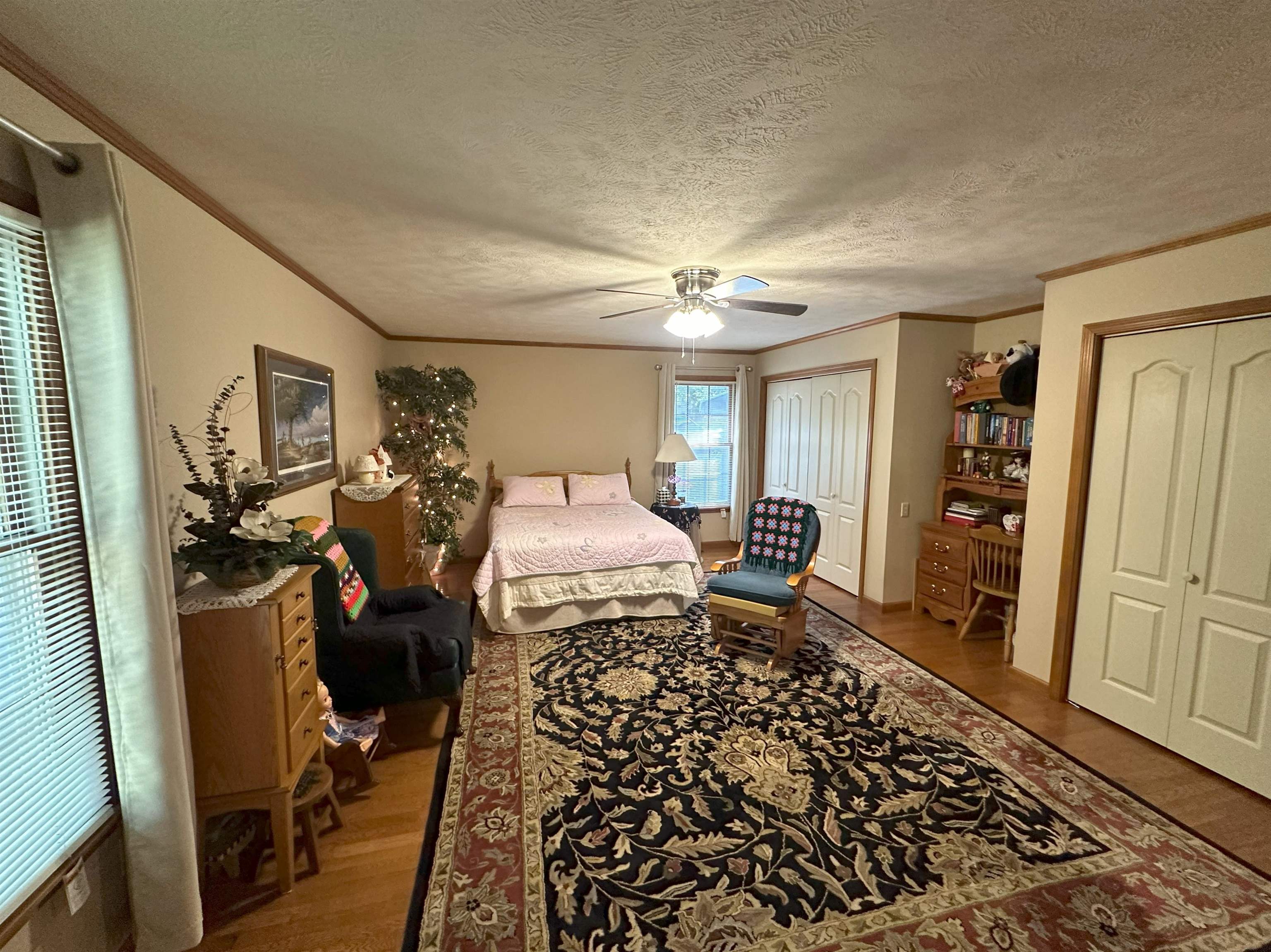 Bedroom with ornamental molding, a textured ceiling, hardwood / wood-style flooring, and ceiling fan