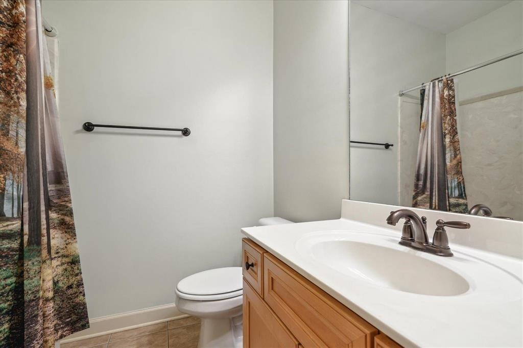 Shared hall bath with tile floor and shower/tub combo.