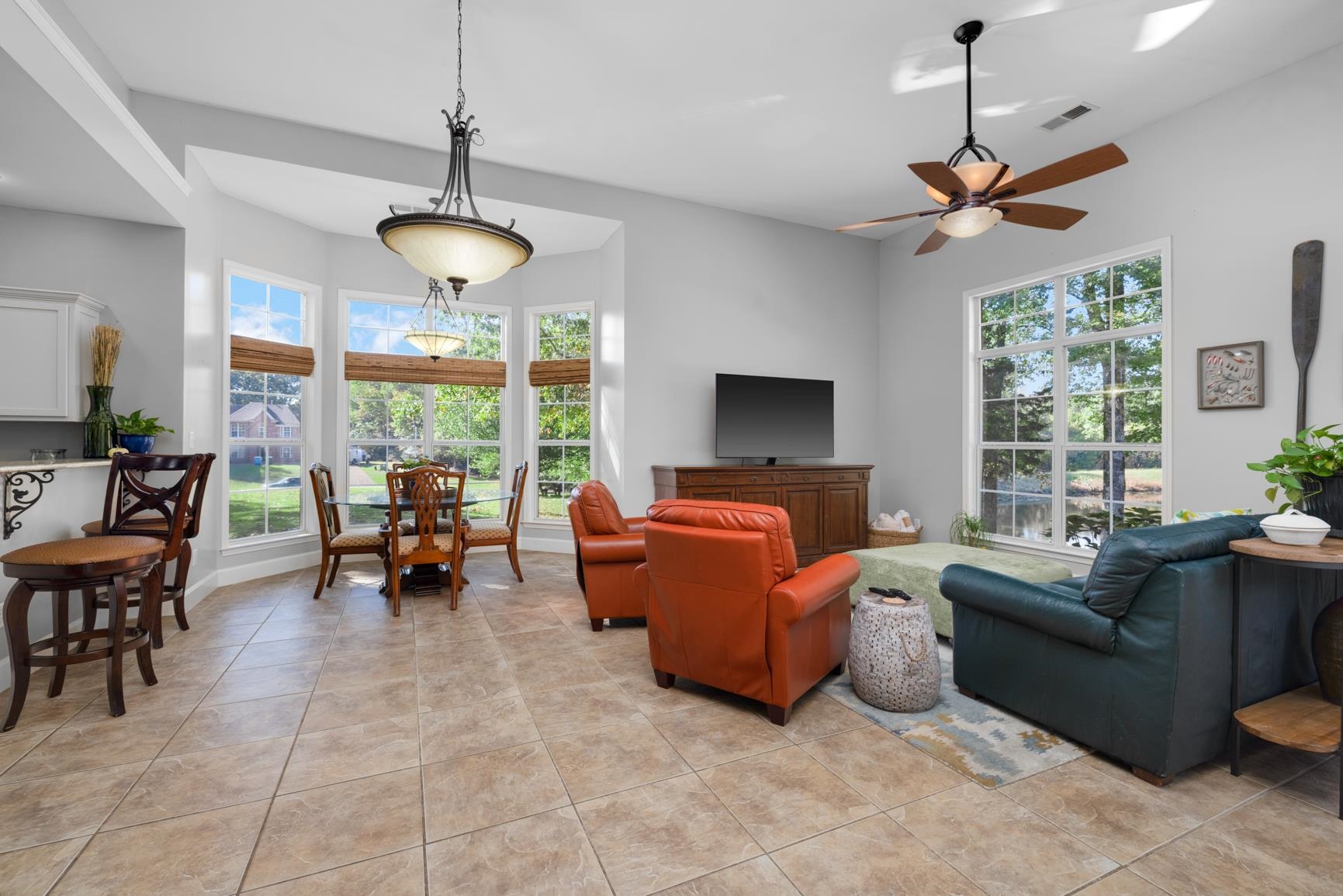 Tiled living room featuring ceiling fan and plenty of natural light