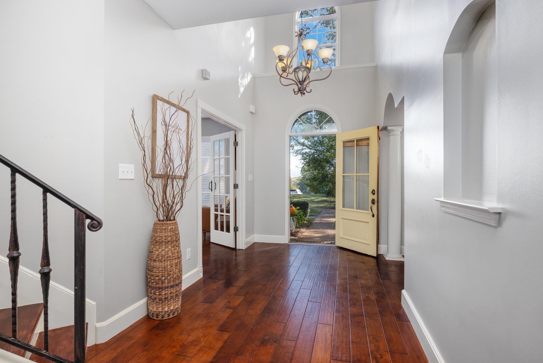 Entrance foyer with a high ceiling, an inviting chandelier, and dark hardwood / wood-style flooring