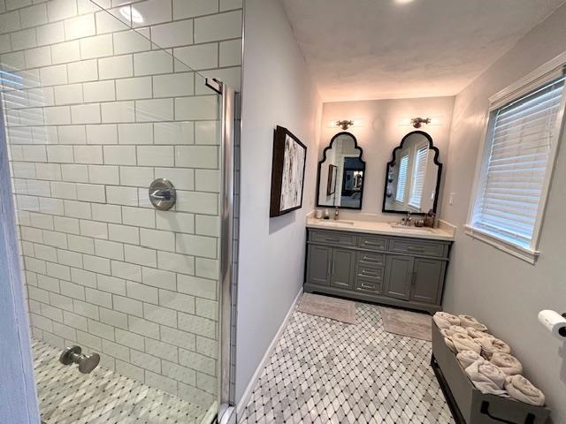 Bathroom featuring a shower with door, tile patterned flooring, and vanity