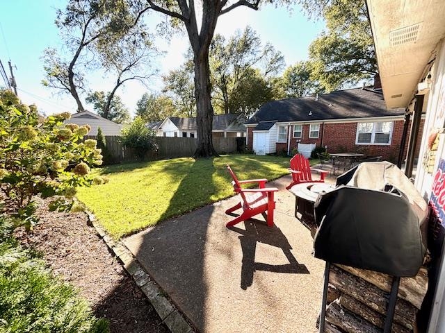 View of yard featuring a patio, a storage unit, and an outdoor fire pit