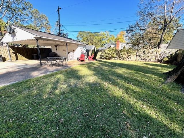 View of yard featuring a patio and large 2 car carport with storage room