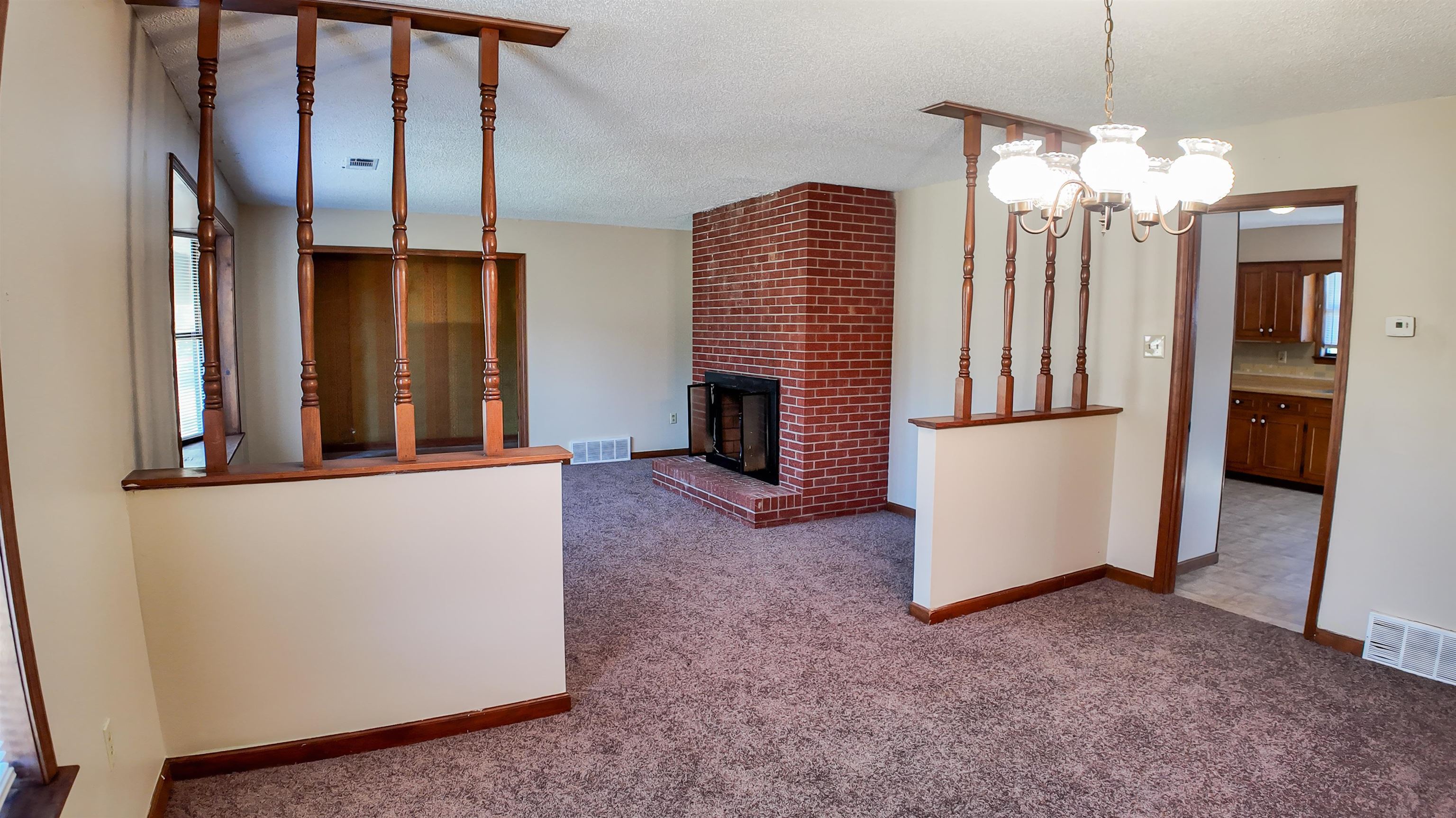 living room featuring carpet, a fireplace, and a textured ceiling