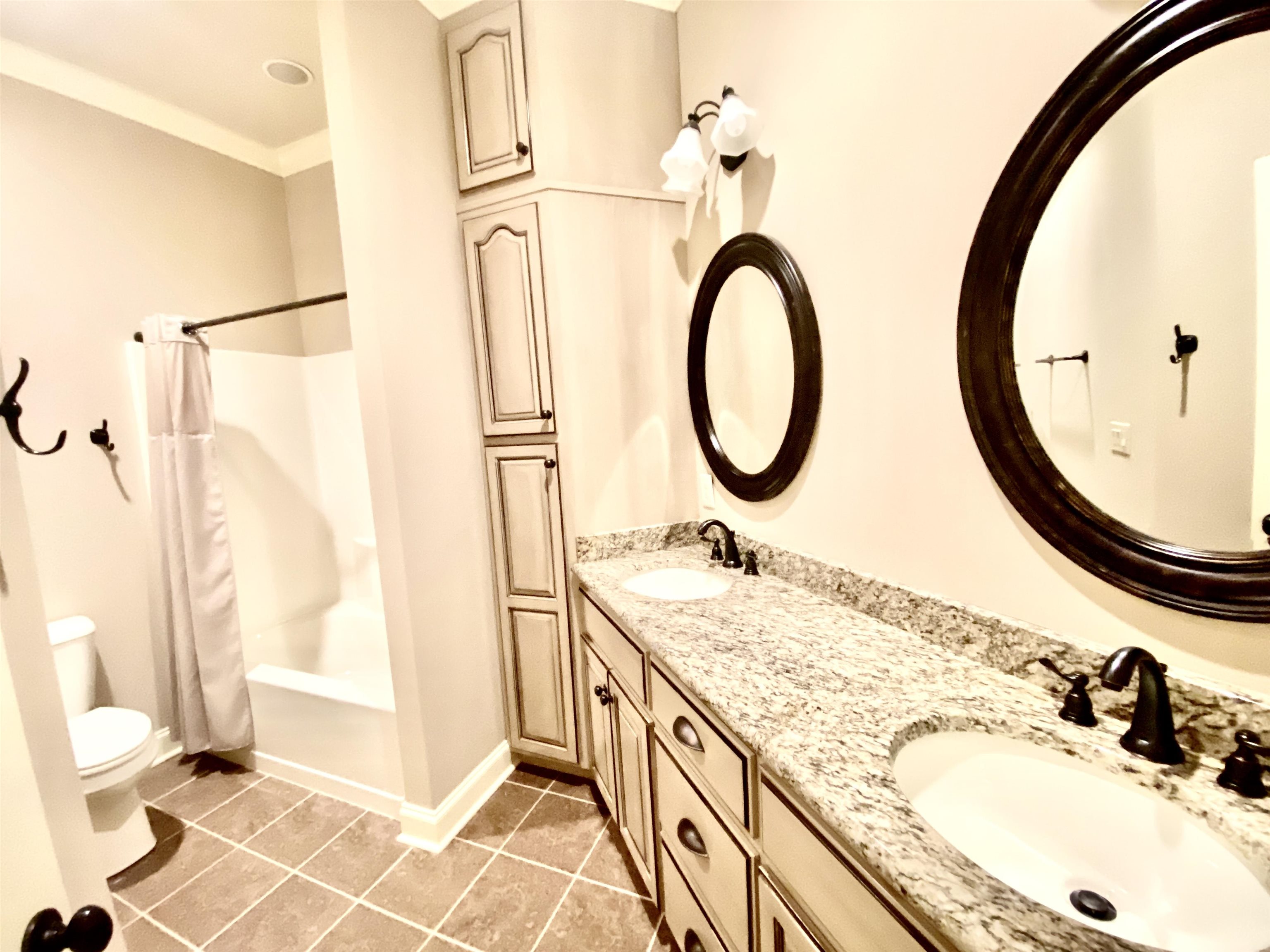 Bathroom with vanity, crown molding, tile floors, and a shower.