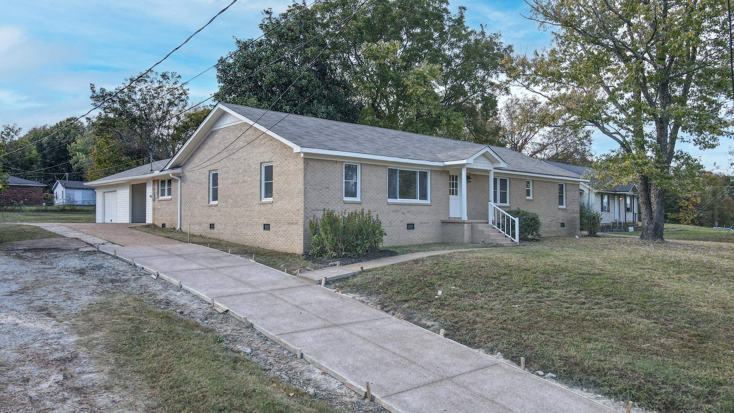 View of front of property with an outbuilding, a front lawn, and a garage